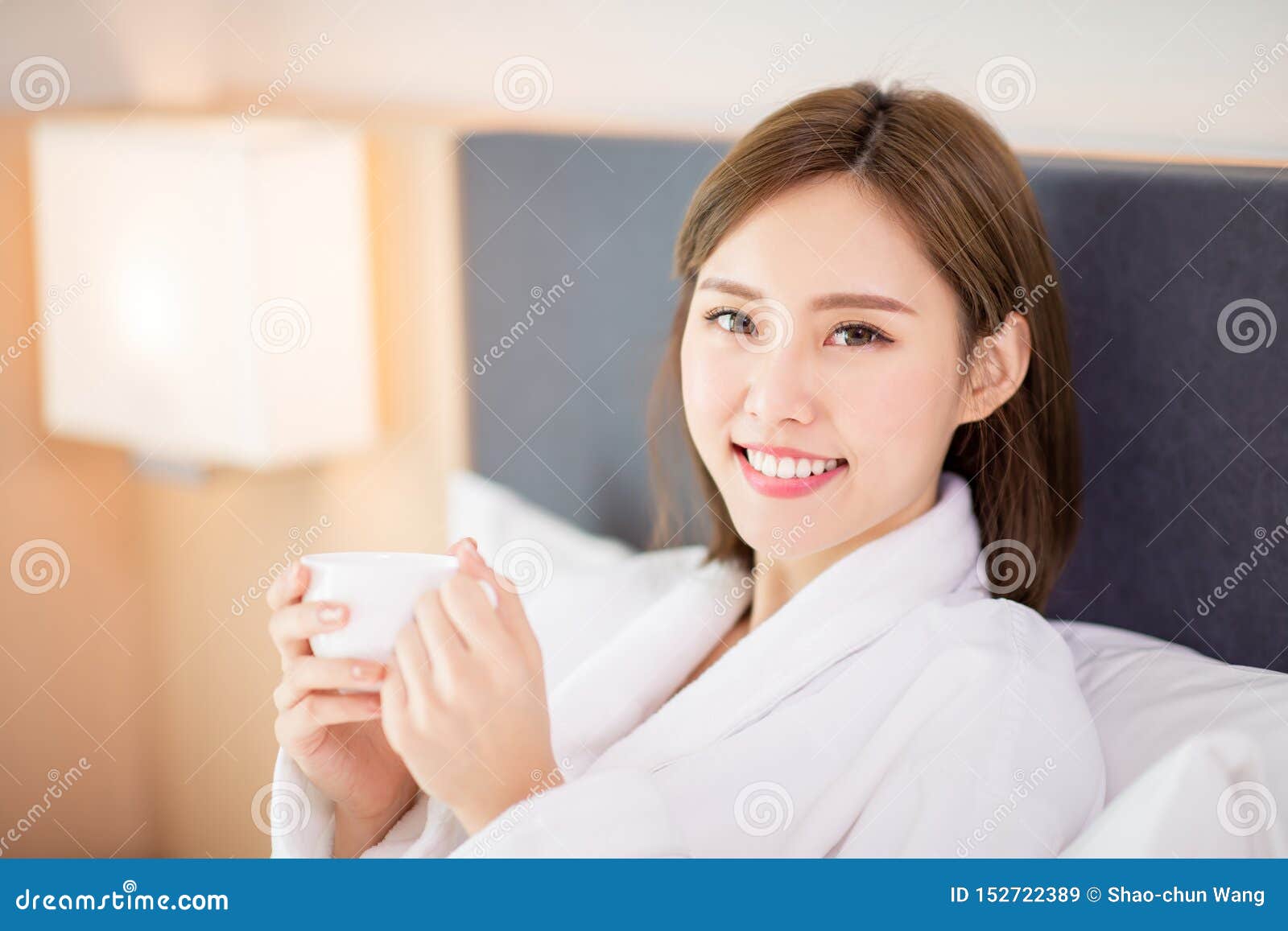 La mujer goza del café por mañana. Café asiático de la bebida de la mujer de la belleza y disfrutar de una mañana maravillosa en el hotel