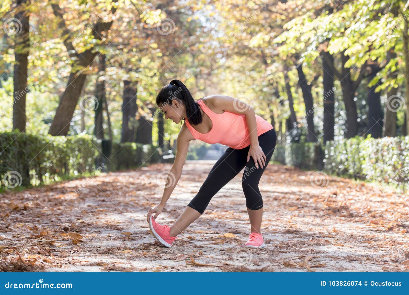 La mujer sonriente joven de los deportes felices hace ejercicios del deporte