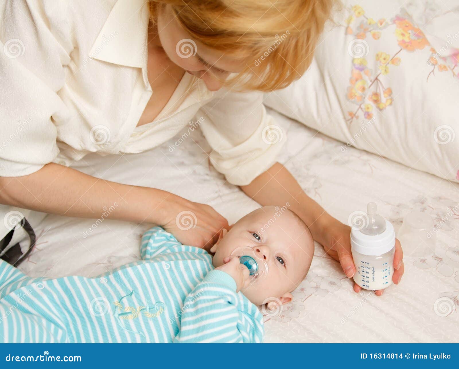 La mujer introduce al niño con una mezcla de una pequeña botella