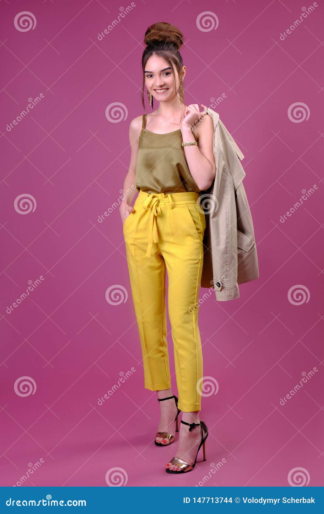 La Mujer Joven En Pantalones Amarillos Está Sosteniendo Chaqueta En Su Hombro Risa Tiro Del Estudio De La Longitud Del Tres Foto de archivo - Imagen de retrato: 147713744