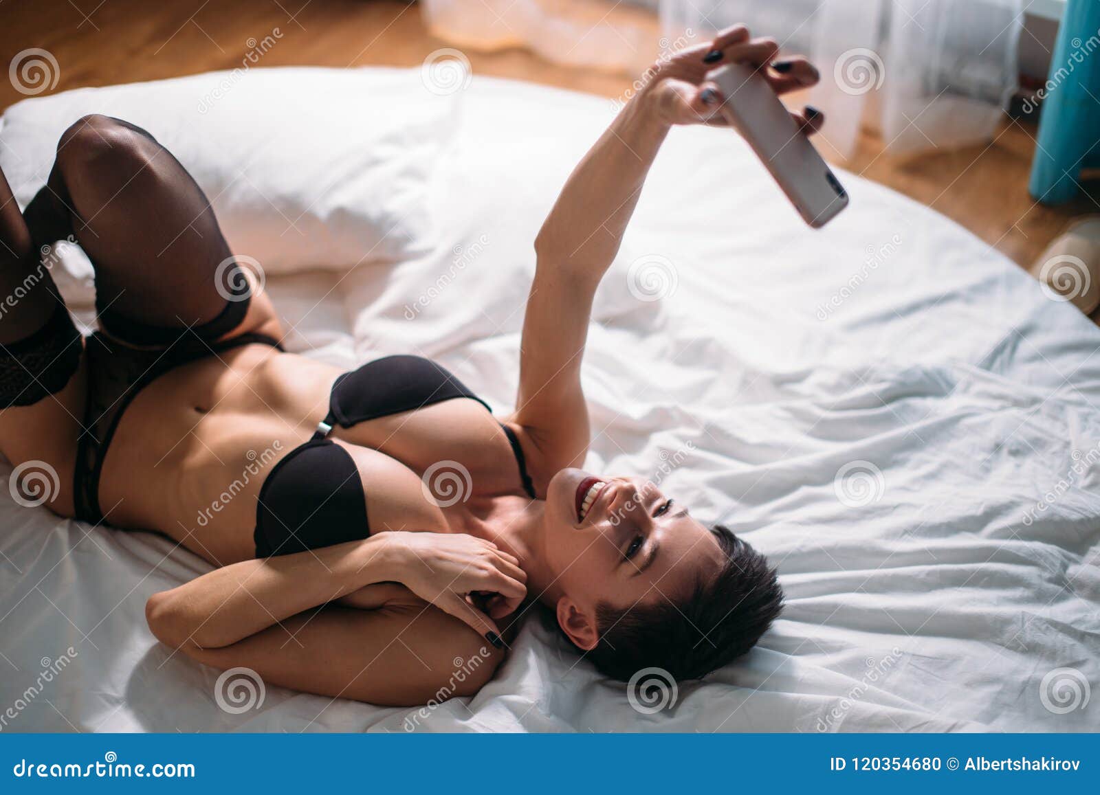 La Mujer Morena Atractiva Atractiva Miente En Cama En Ropa Interior Y  Selfie El Tomar En El Teléfono Foto de archivo - Imagen de mirando,  atractivo: 120354680