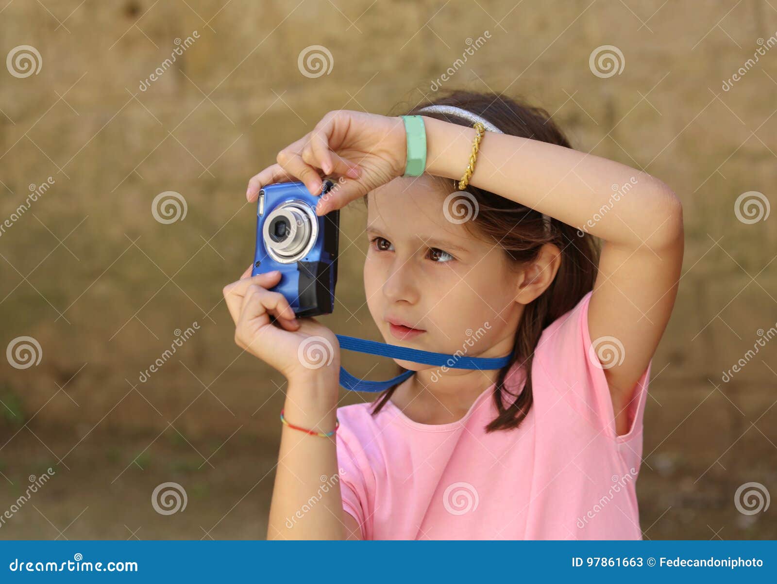 La Niña Toma Una Foto Con La Cámara Digital Imagen de archivo