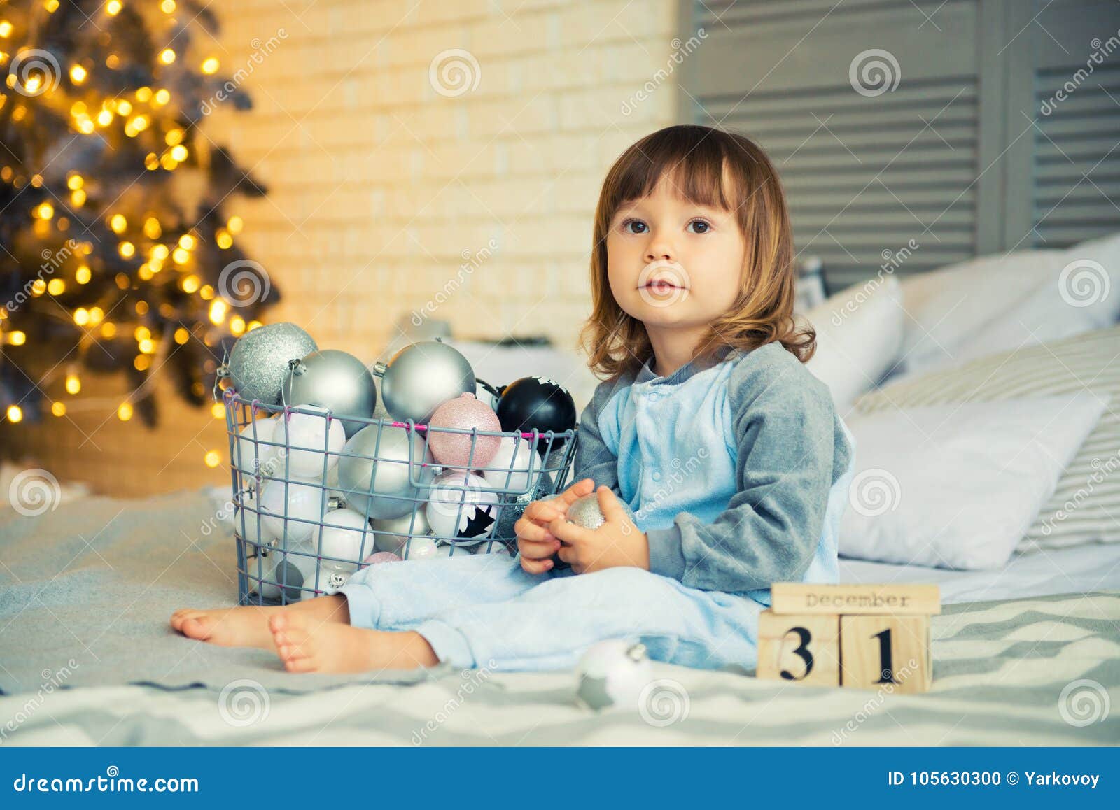 La Pequeña Niña Linda Es 2 Años Que Se Sientan Cerca Del Árbol De Navidad Y  Que Miran El Calendario. 31 De Diciembre. Fotos, retratos, imágenes y  fotografía de archivo libres de