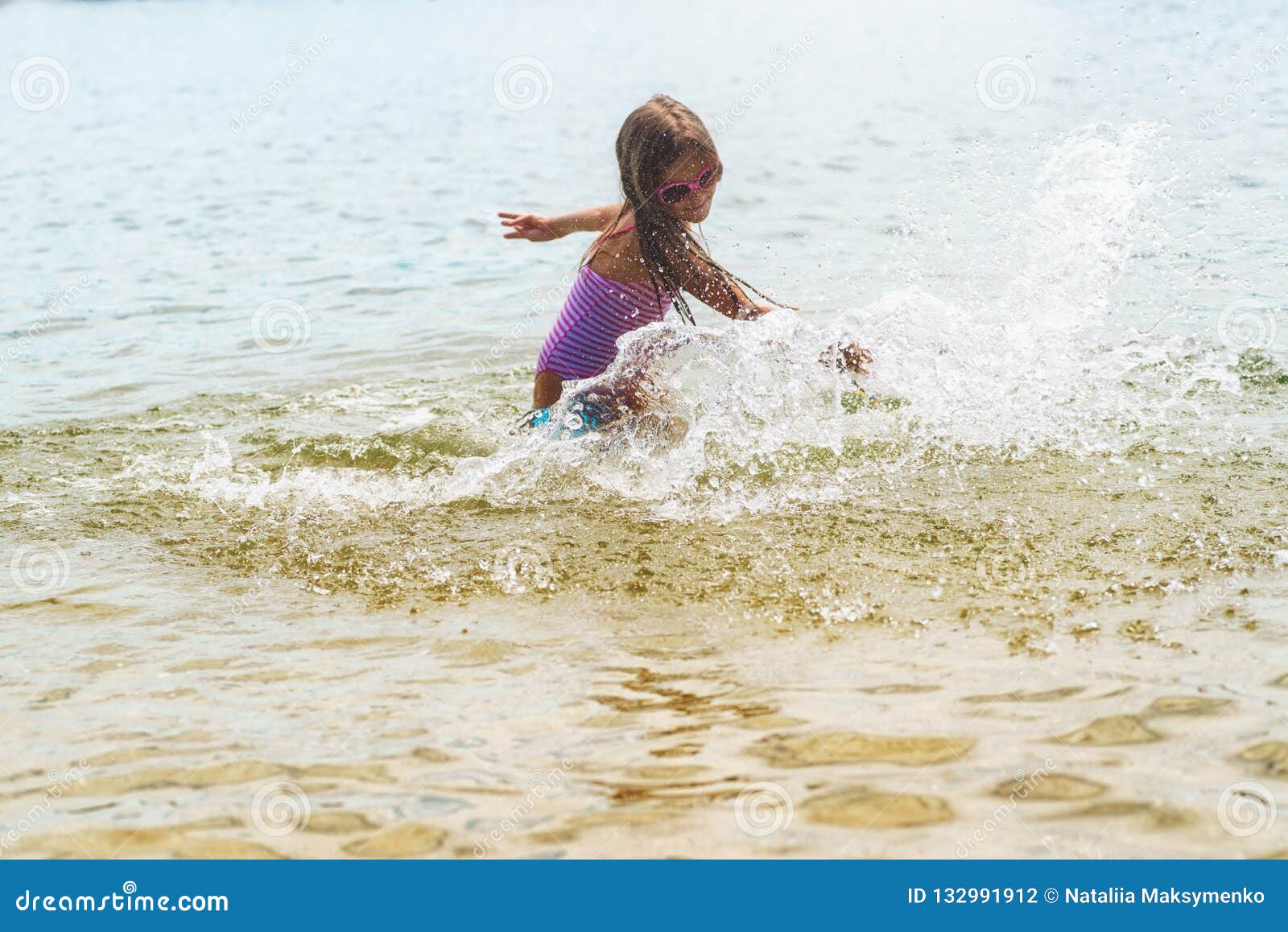 La Petite Fille Heureuse Jouant En Eau Peu Profonde Ondule Petite Fille