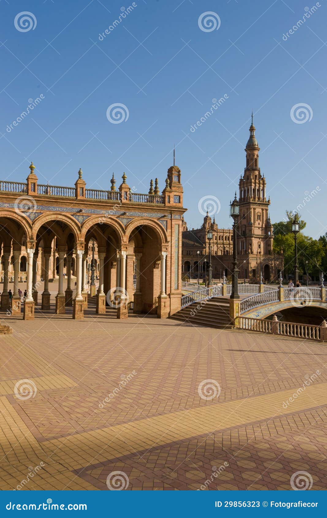 Famous Plaza de Espana, Sevilla, Spagna. La plaza de España, progettato da Aníbal González, era un edificio principale costruito sul bordo del parco di Maria Luisa per montrare le mostre dell'industria e della tecnologia della Spagna. González ha combinato una miscela dell'art deco e “della derisione degli anni 20 Mudejar„ e i Neo-Mudéjar stili. Il complesso di de España della plaza è un metà-cerchio enorme con le costruzioni che funzionano continuamente intorno al bordo accessibile sopra il fossato dal numeroso damerino