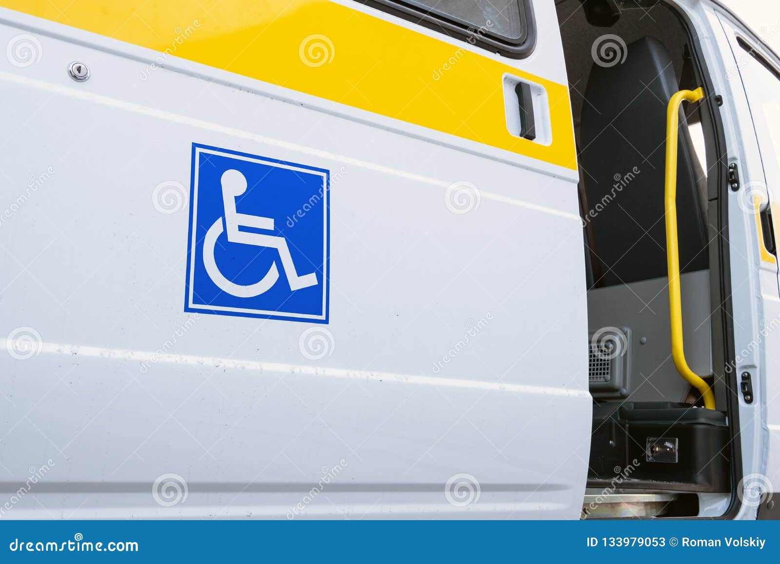 La porta aperta di un veicolo specializzato per la gente con le inabilità Bus bianco con un segno blu per gli handicappati Barra. Bus bianco con un segno blu per gli handicappati La porta aperta di un veicolo specializzato per la gente con le inabilità Barra e corrimano gialli