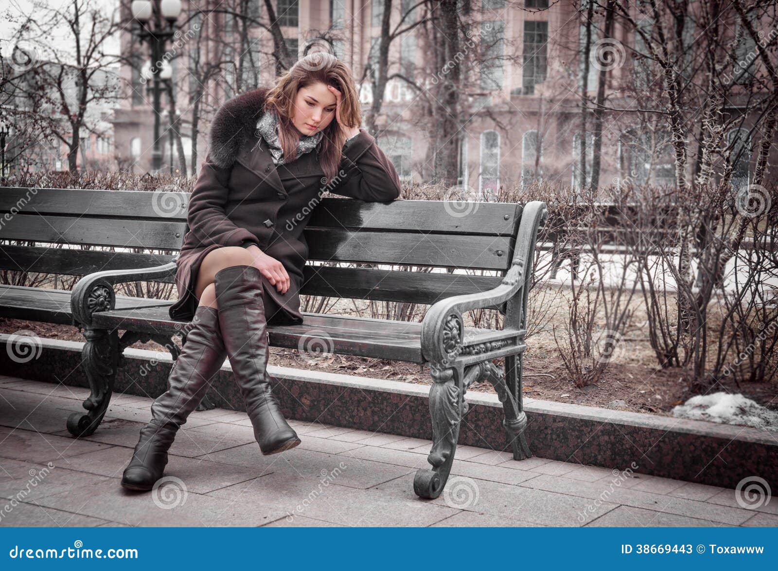 La ragazza triste si siede sul banco all'aperto