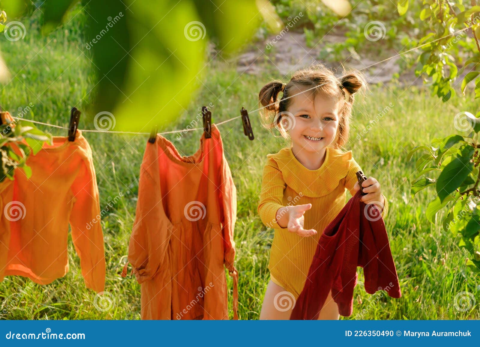 La Ropa De Los Niños Se Está Secando En El Jardín Al Aire Libre Foto de  archivo - Imagen de ropas, clothespin: 226350490