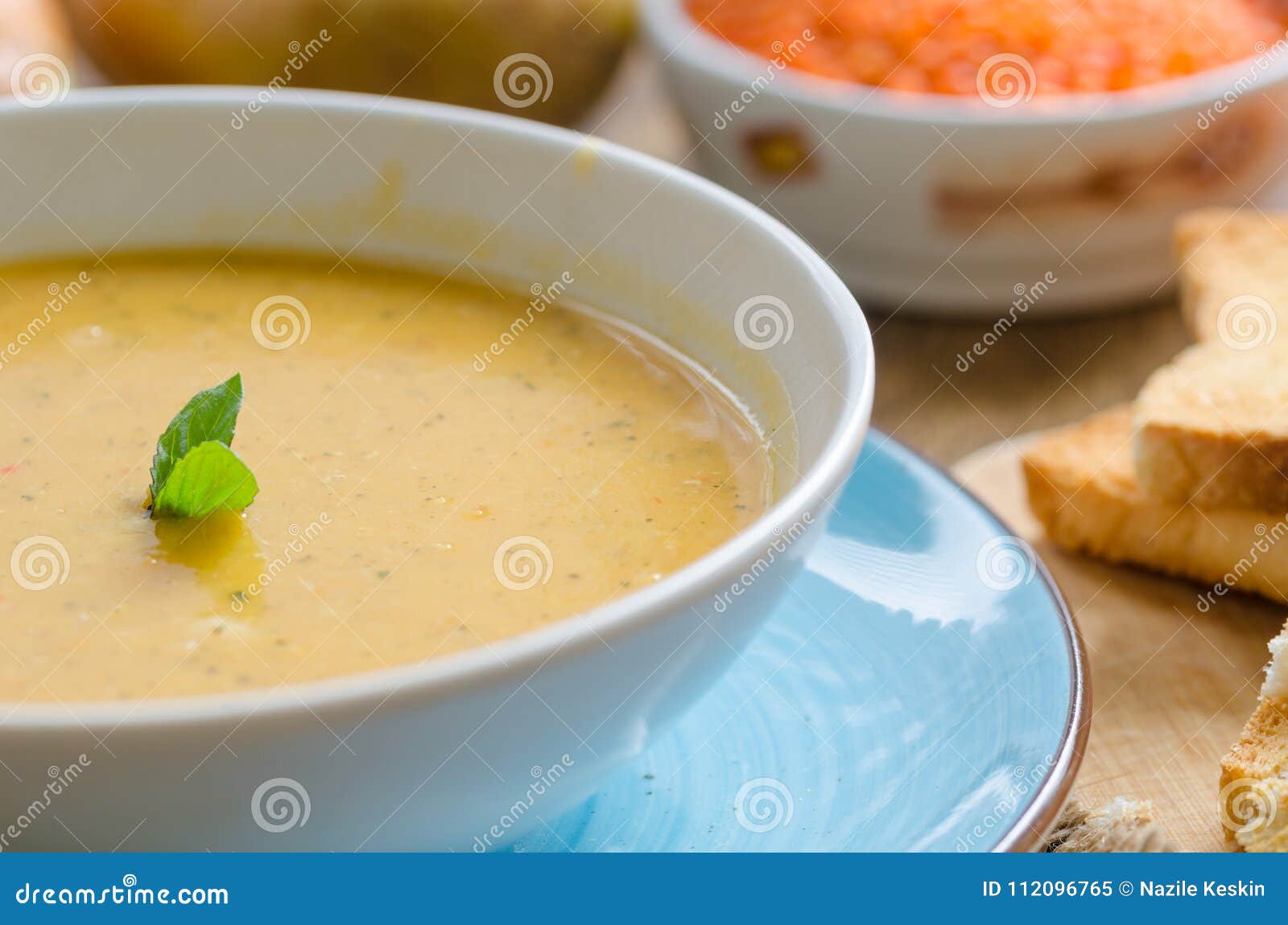 La sopa de lenteja en la placa blanca está en la tabla Hay lentejas, zanahorias, pan, cebollas en la tabla