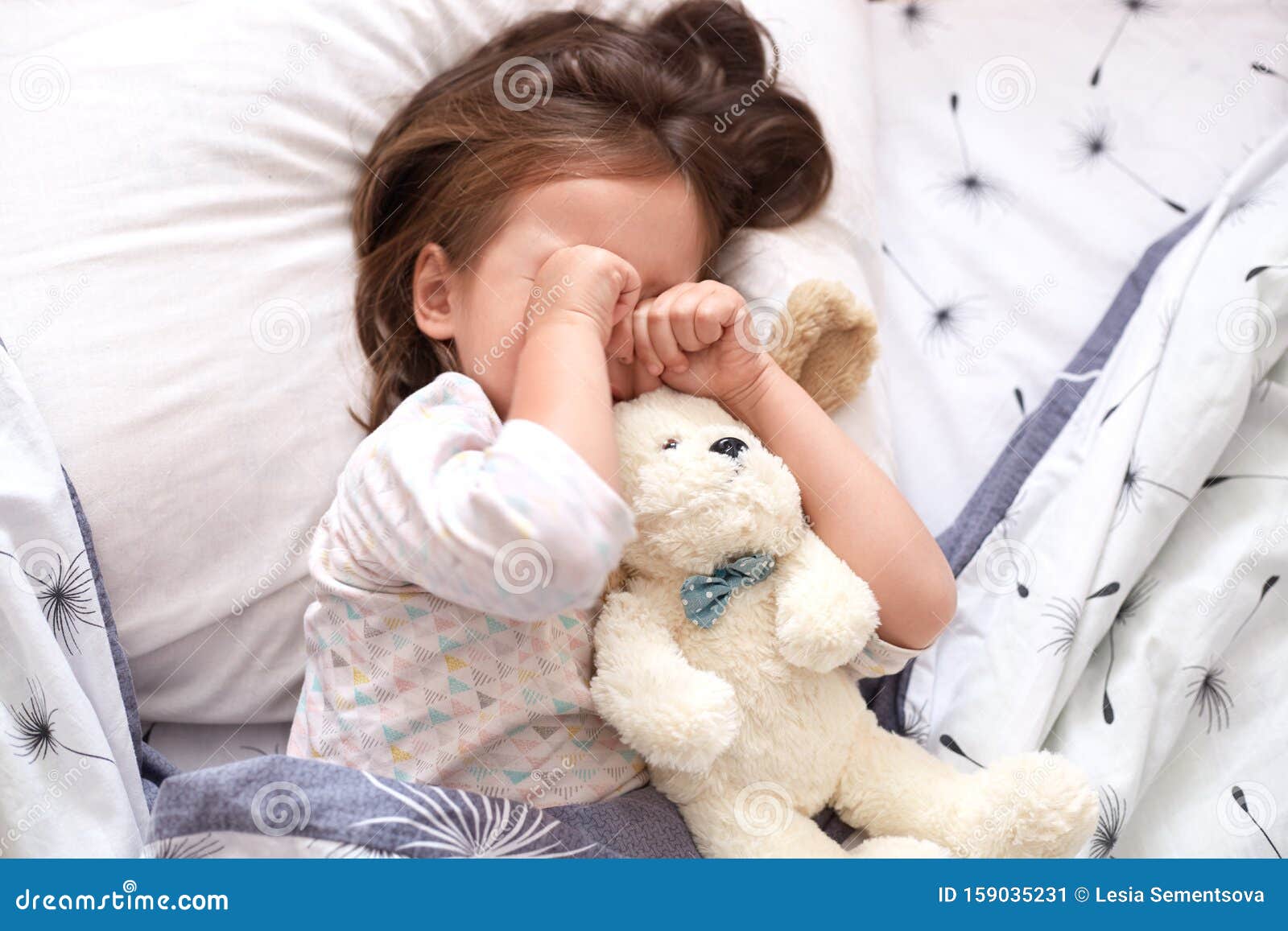 La Vista Superior De La Niñita Acostada Con Oso De Peluche, Estando De Mal Humor, No Quiere Crecer Y Ir Al JardÃn De Niños, Imagen de archivo - Imagen de acostada, niñita: