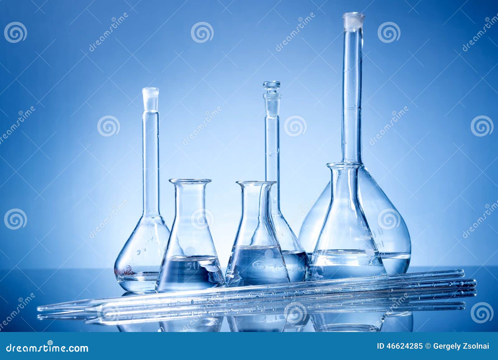 laboratory equipment, glass flasks, pipettes on blue background