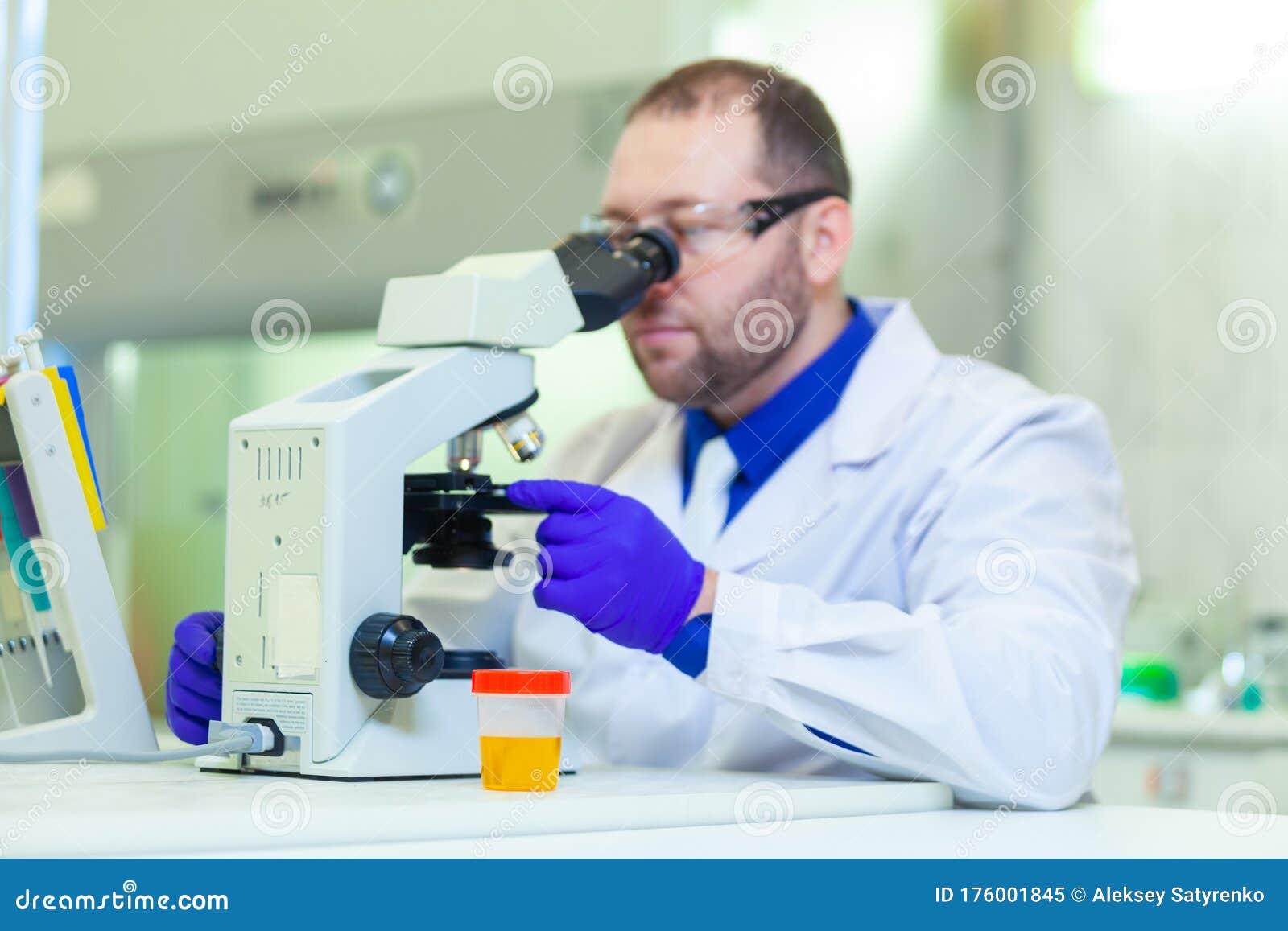 Laboratory Worker Performing Urinalysis Using Microscope and Laboratory