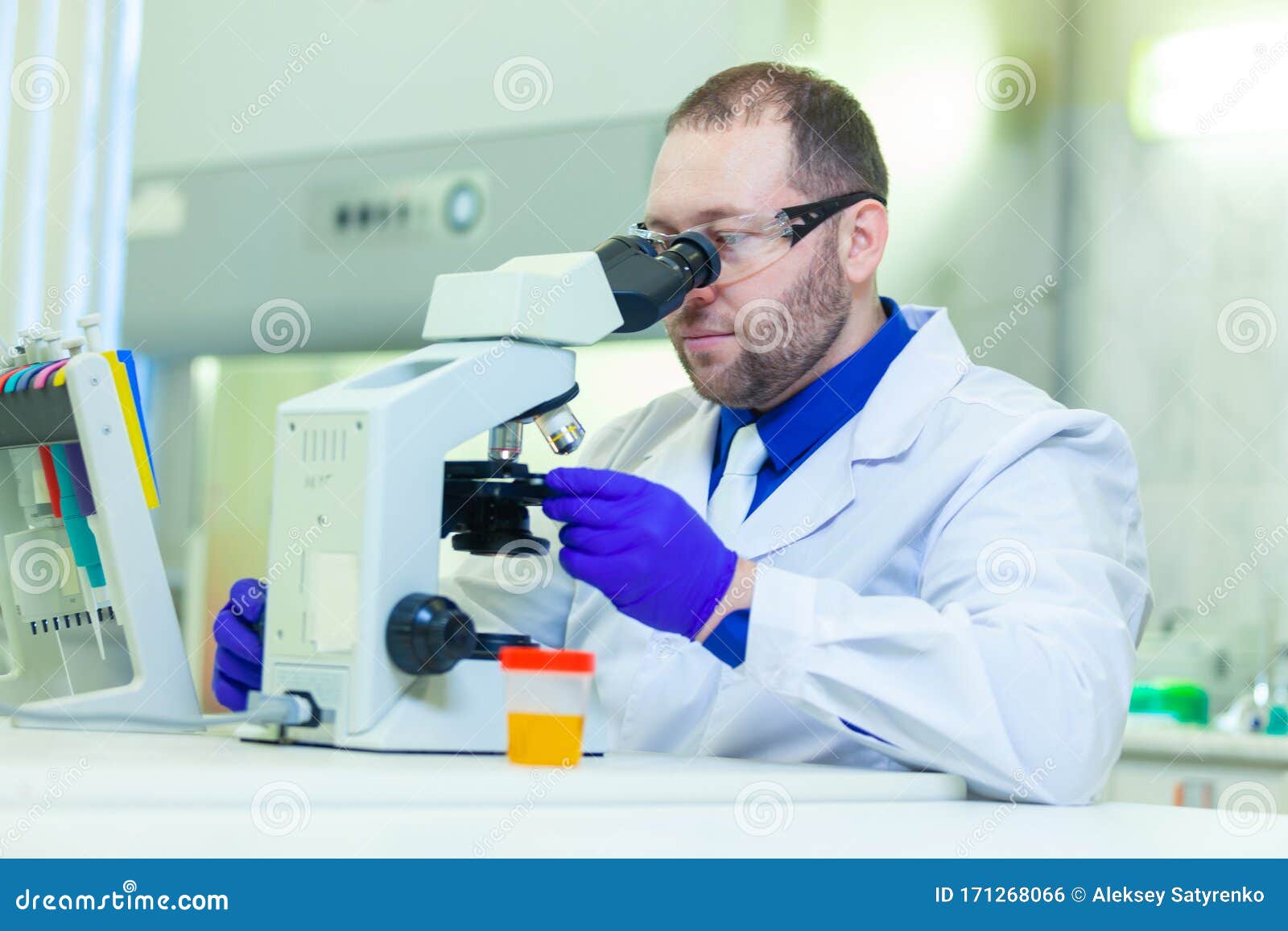 Laboratory Worker Performing Urinalysis Using Microscope and Laboratory