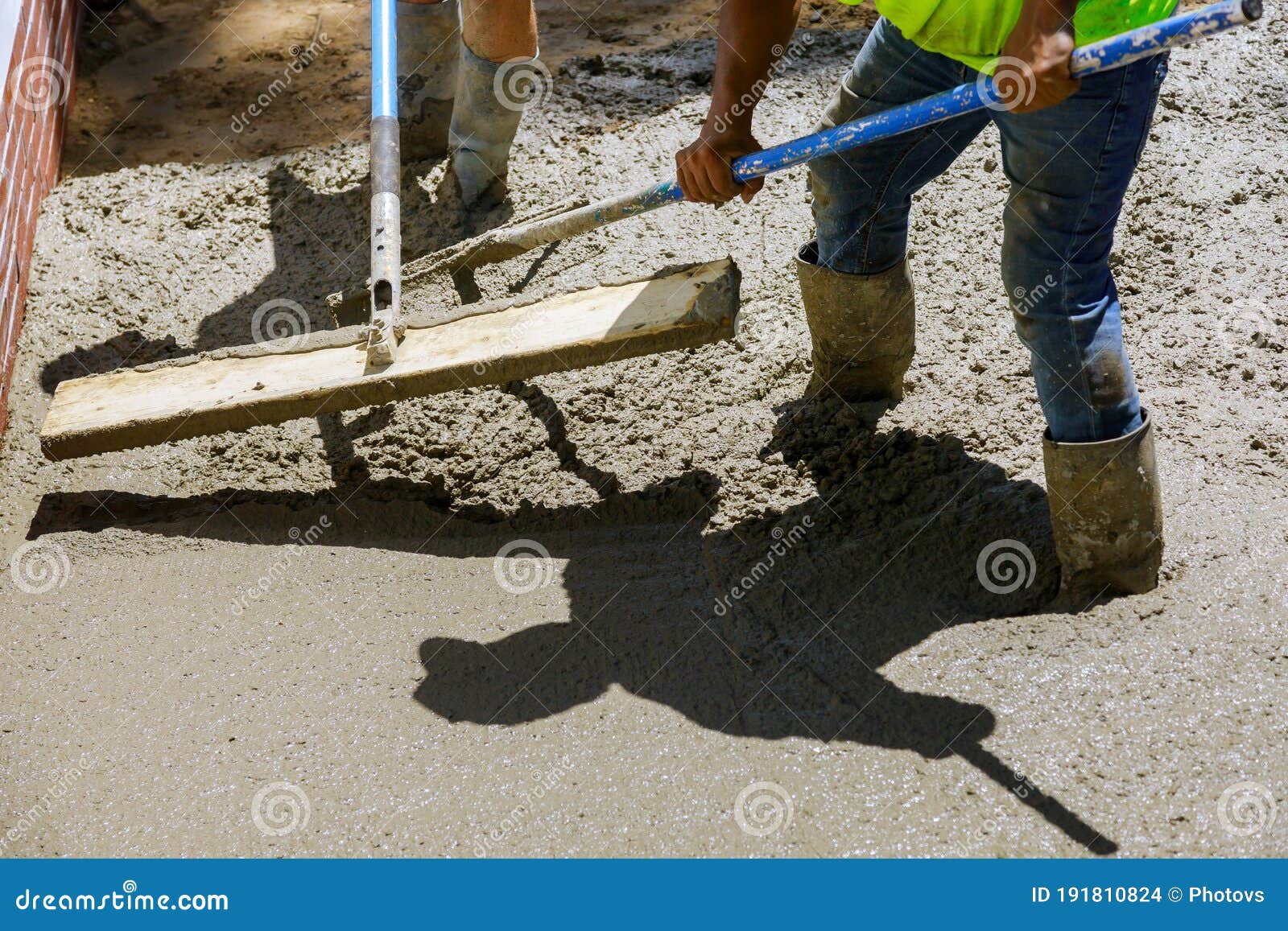 Labour Builders at Construction Site Filling Formwork with Cement