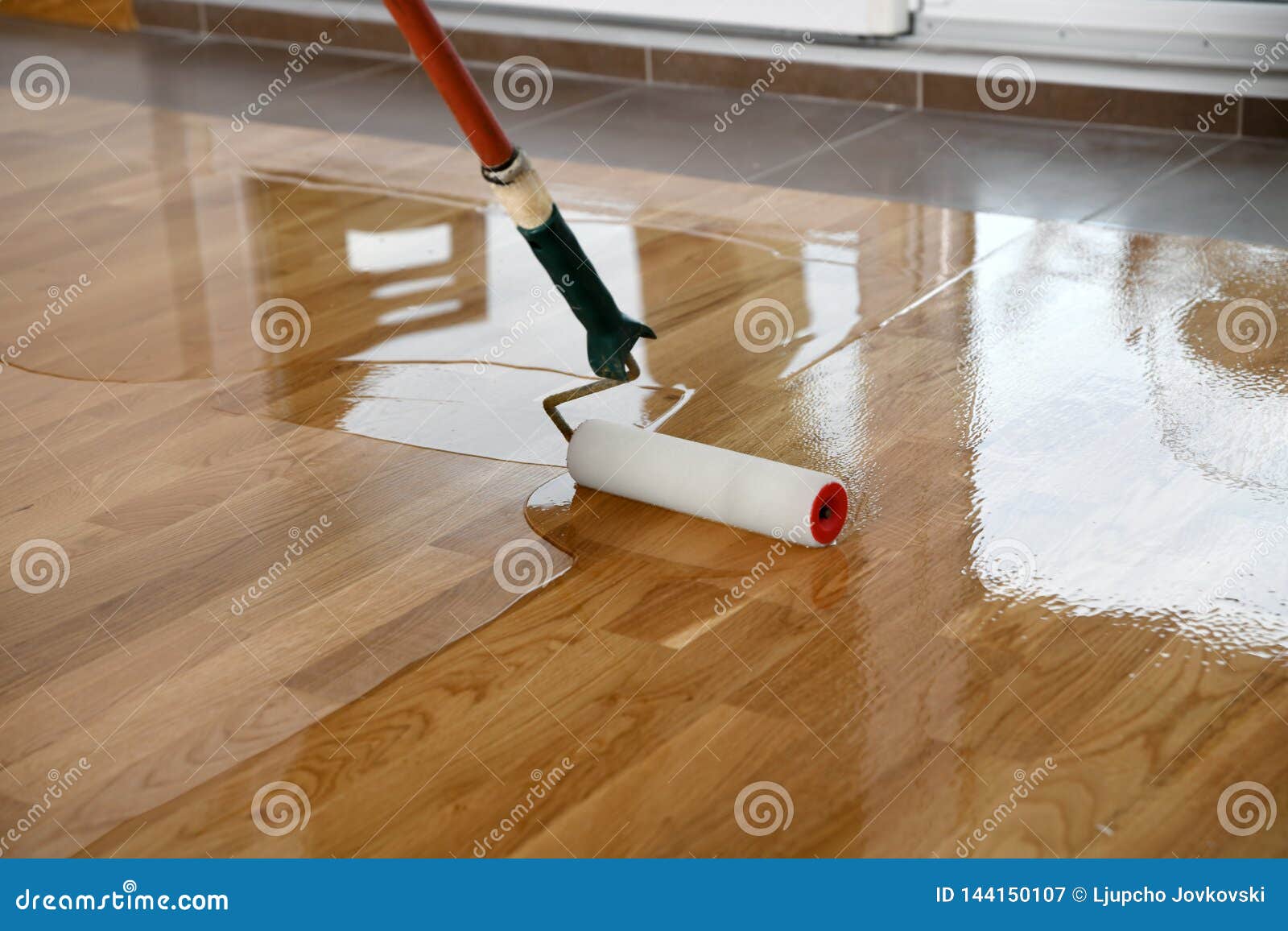 Lacquering Wood Floors Worker Uses A Roller To Coating Floors