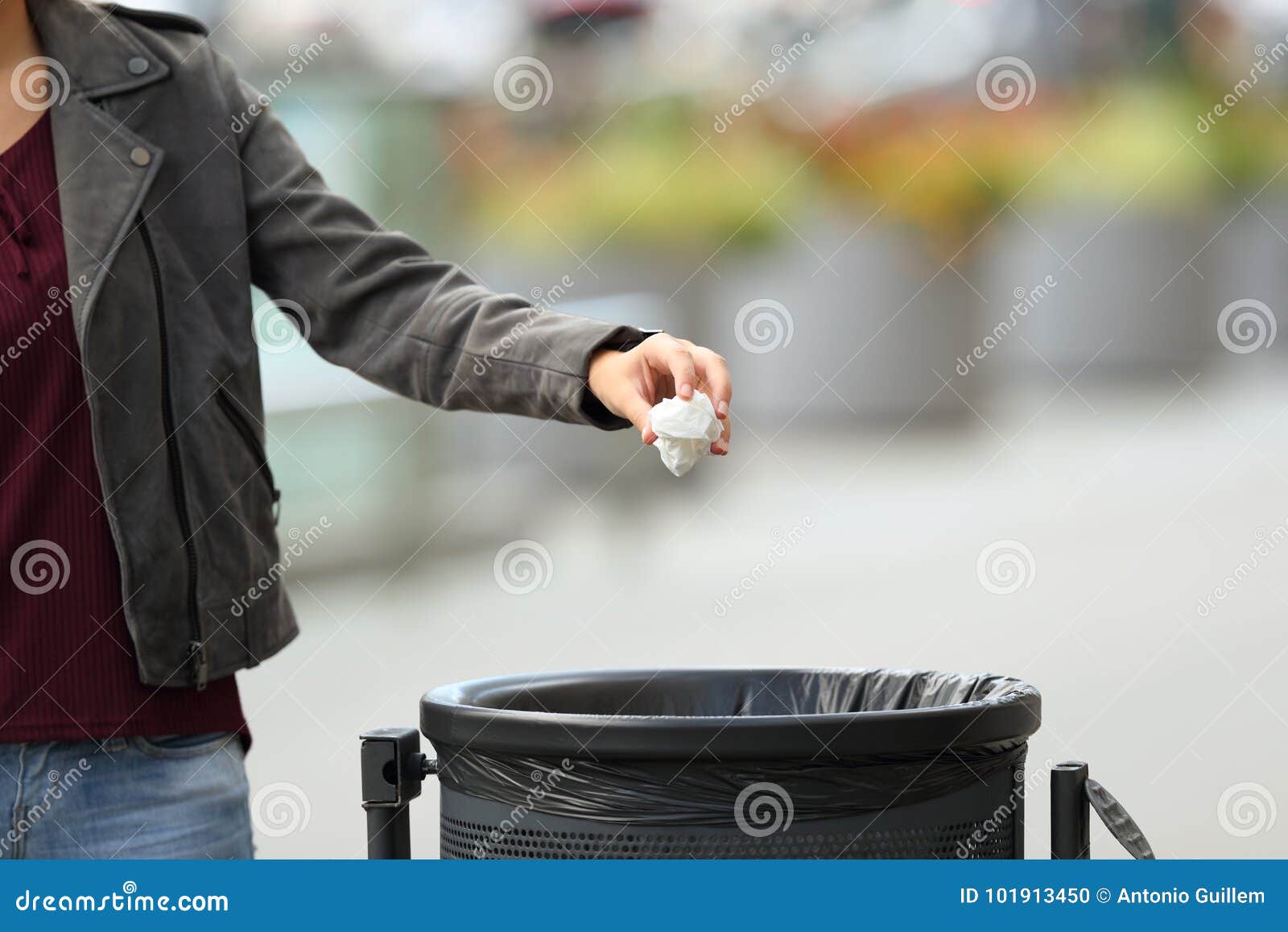 lady hand throwing garbage to a trash bin