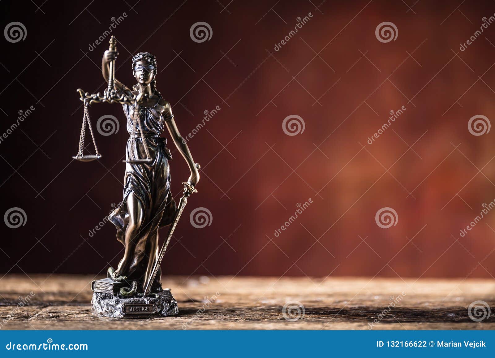 lady justicia holding sword and scale bronze figurine on wooden