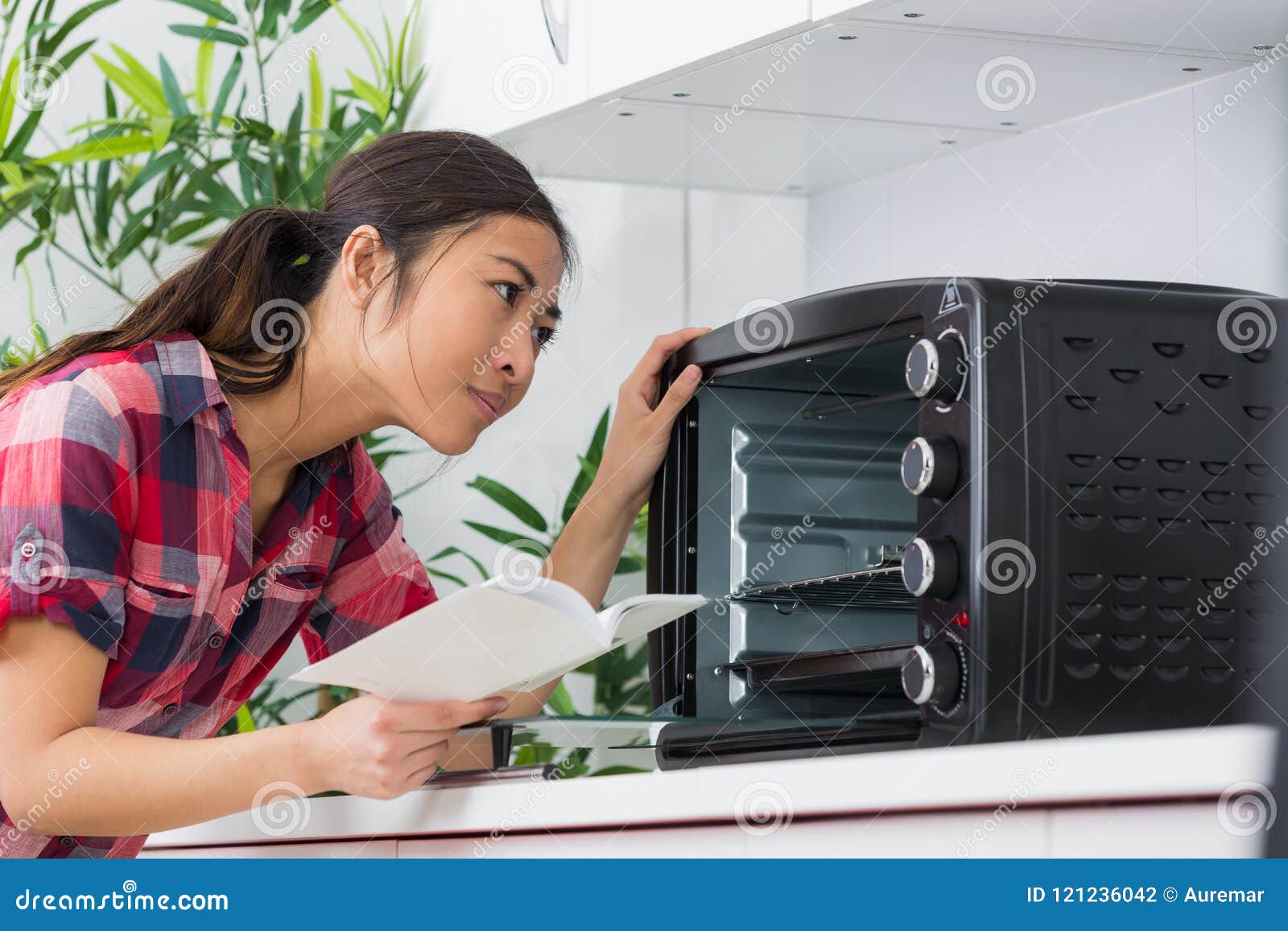 lady looking at countertop oven holding instructions