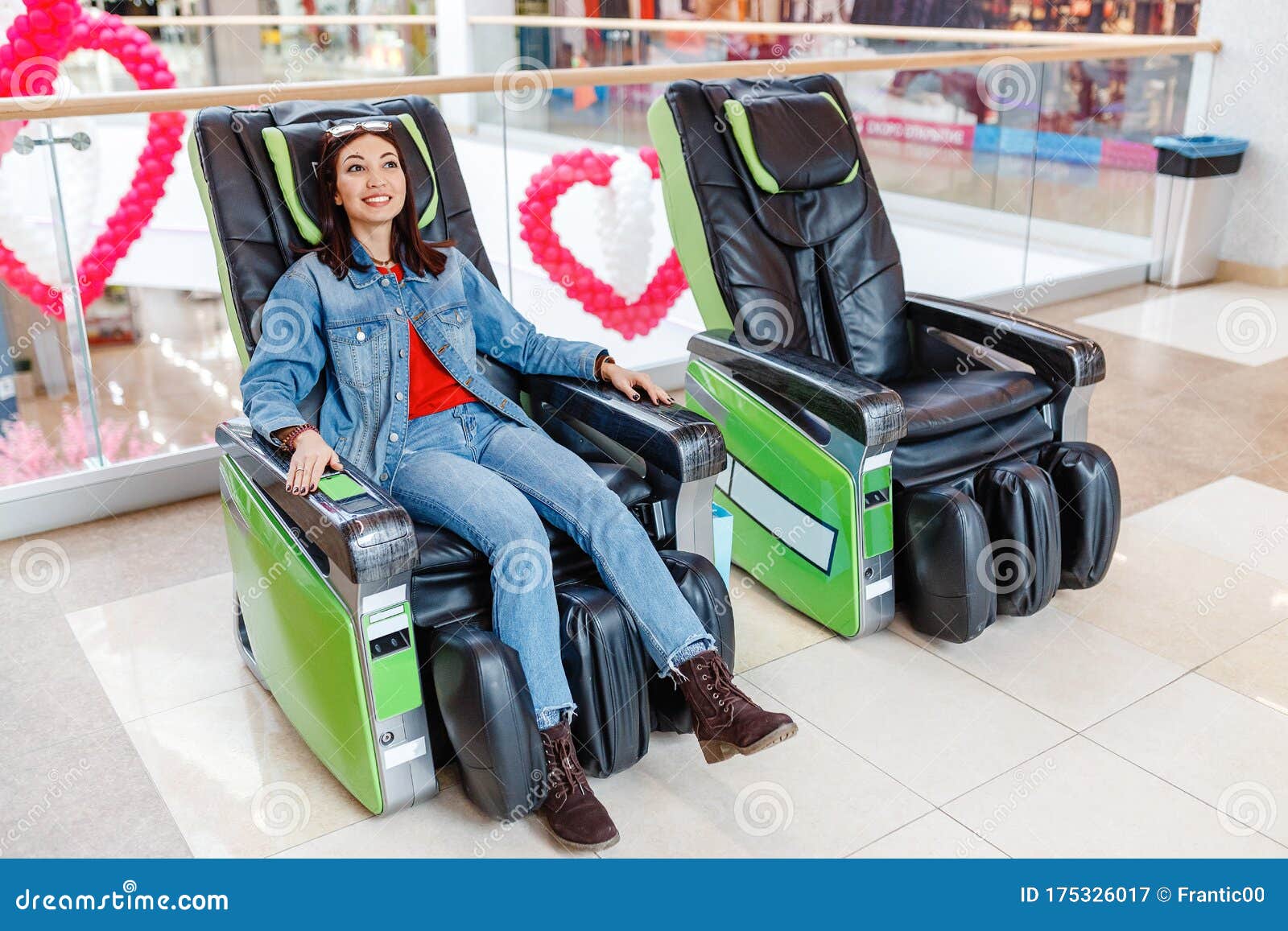 Lady Relaxing after Shopping in the Automated Massage Chair in the Mall