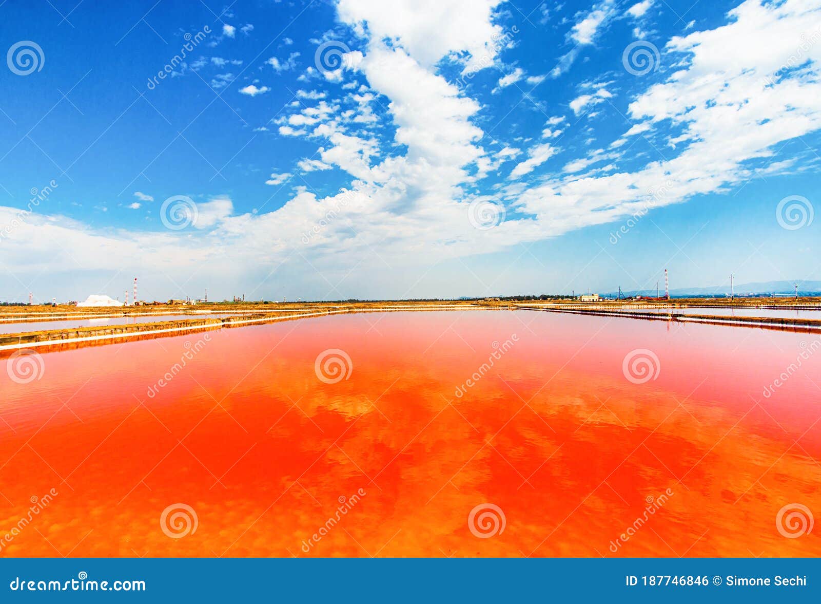 red salt lake with cloudy sky reflection