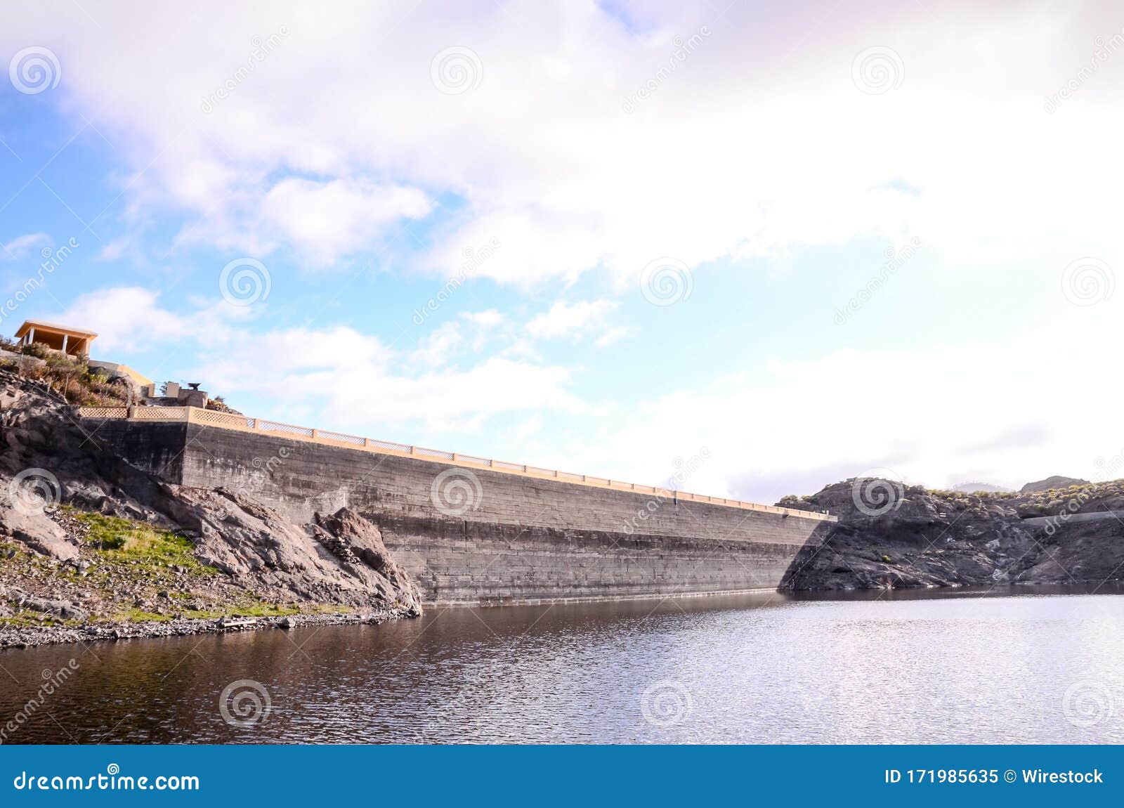 lake water dam in canary islands in spain with a cloudy blue sky in the background