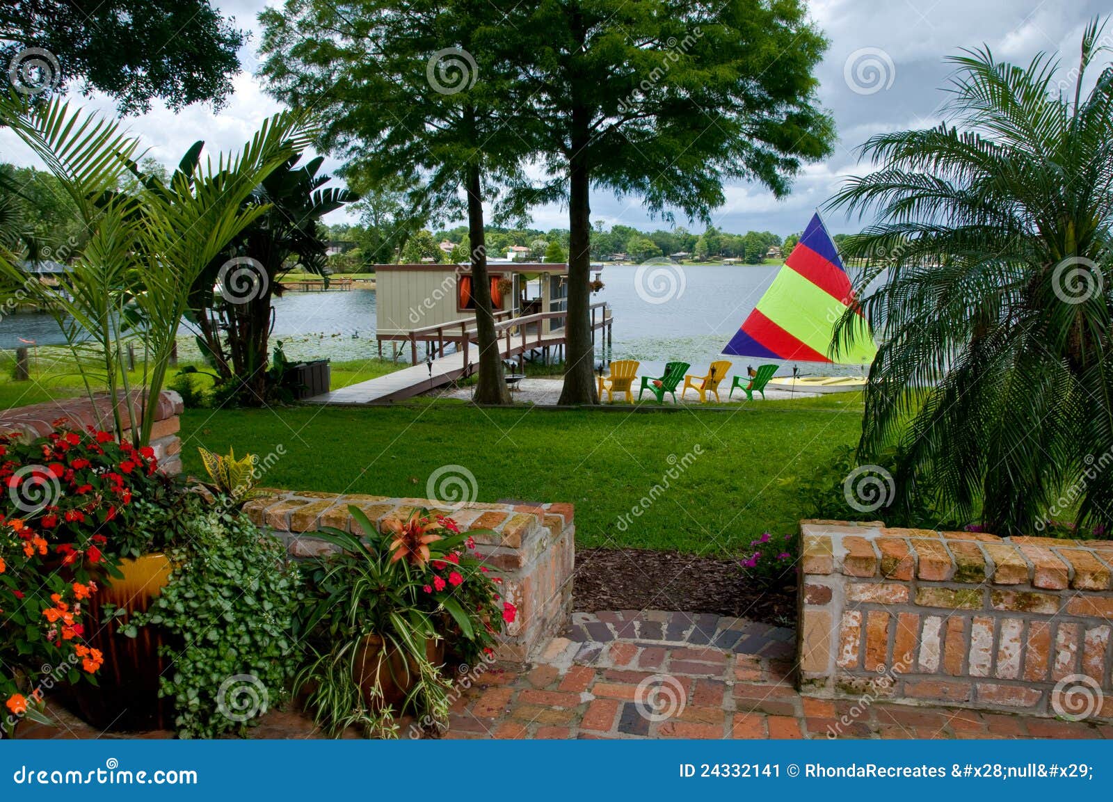 Tropical Lakefront View with Palms and Sailboat in Stock Image Image