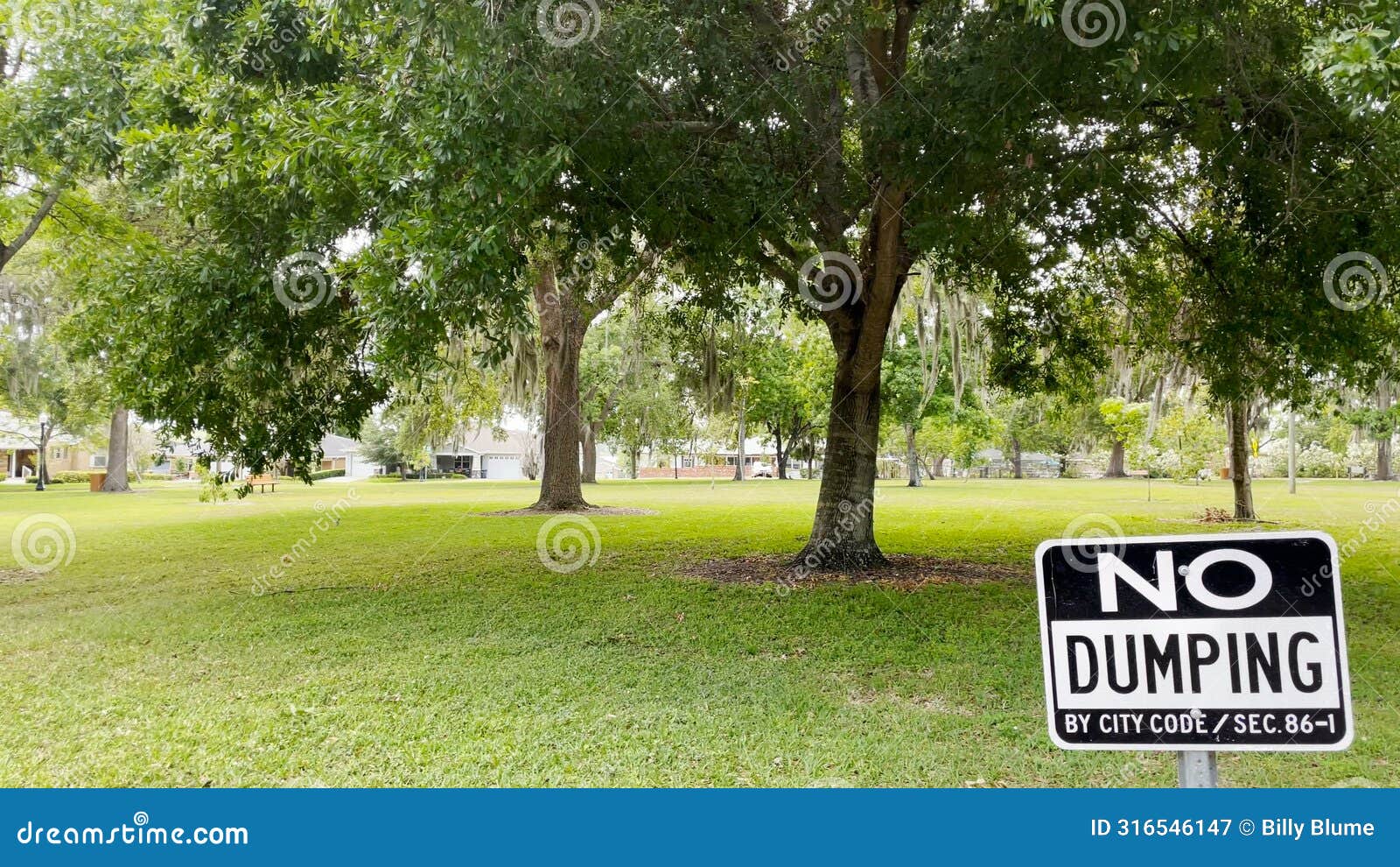 no dumping sign posted ina neighborhood park lush greenery in florida