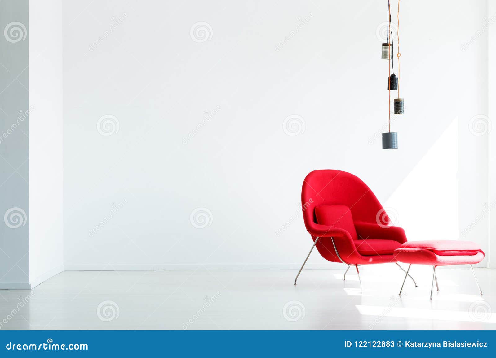 lamps above red armchair in white living room interior with copy