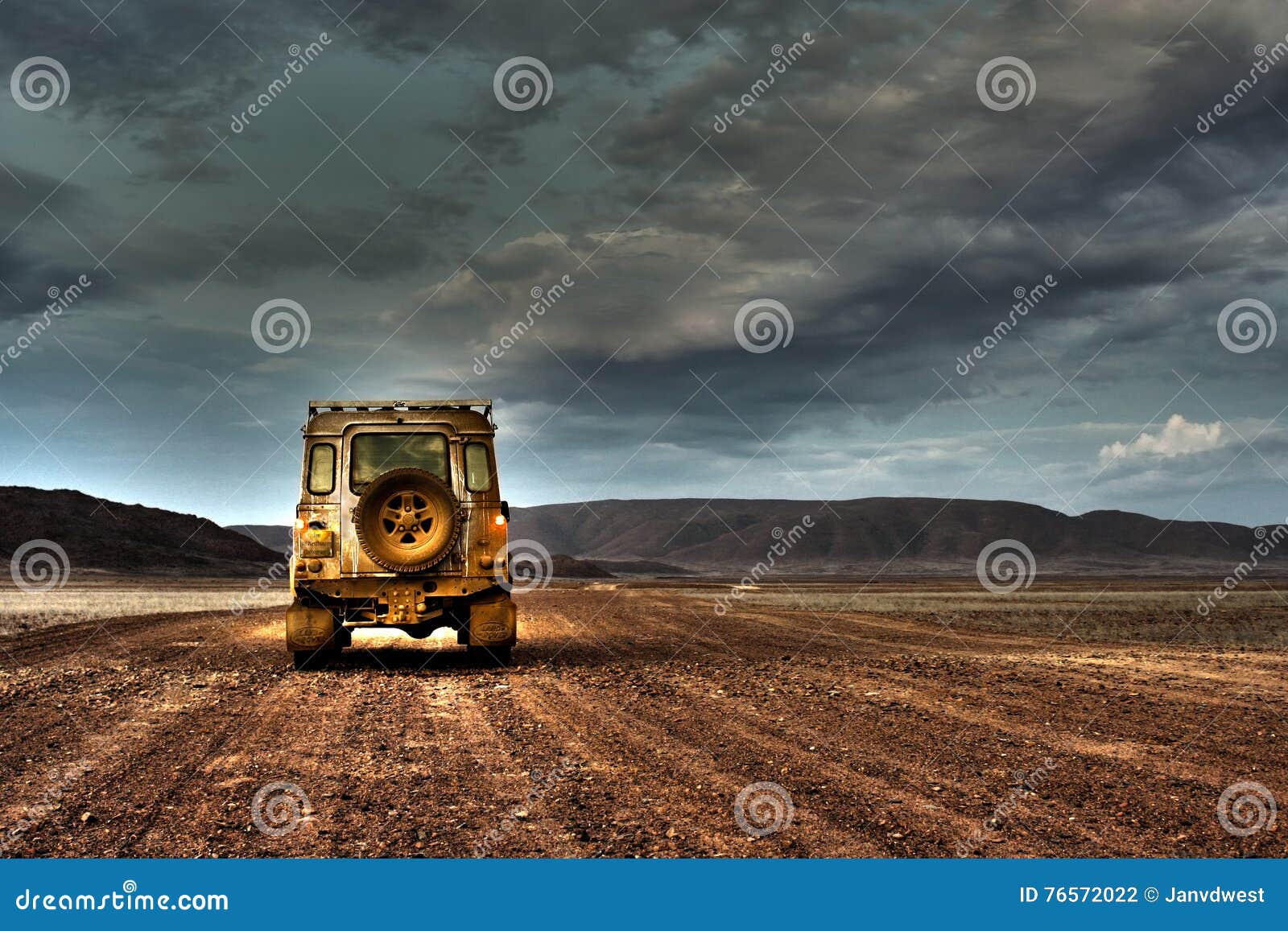 land rover defender on deserted road at dusk