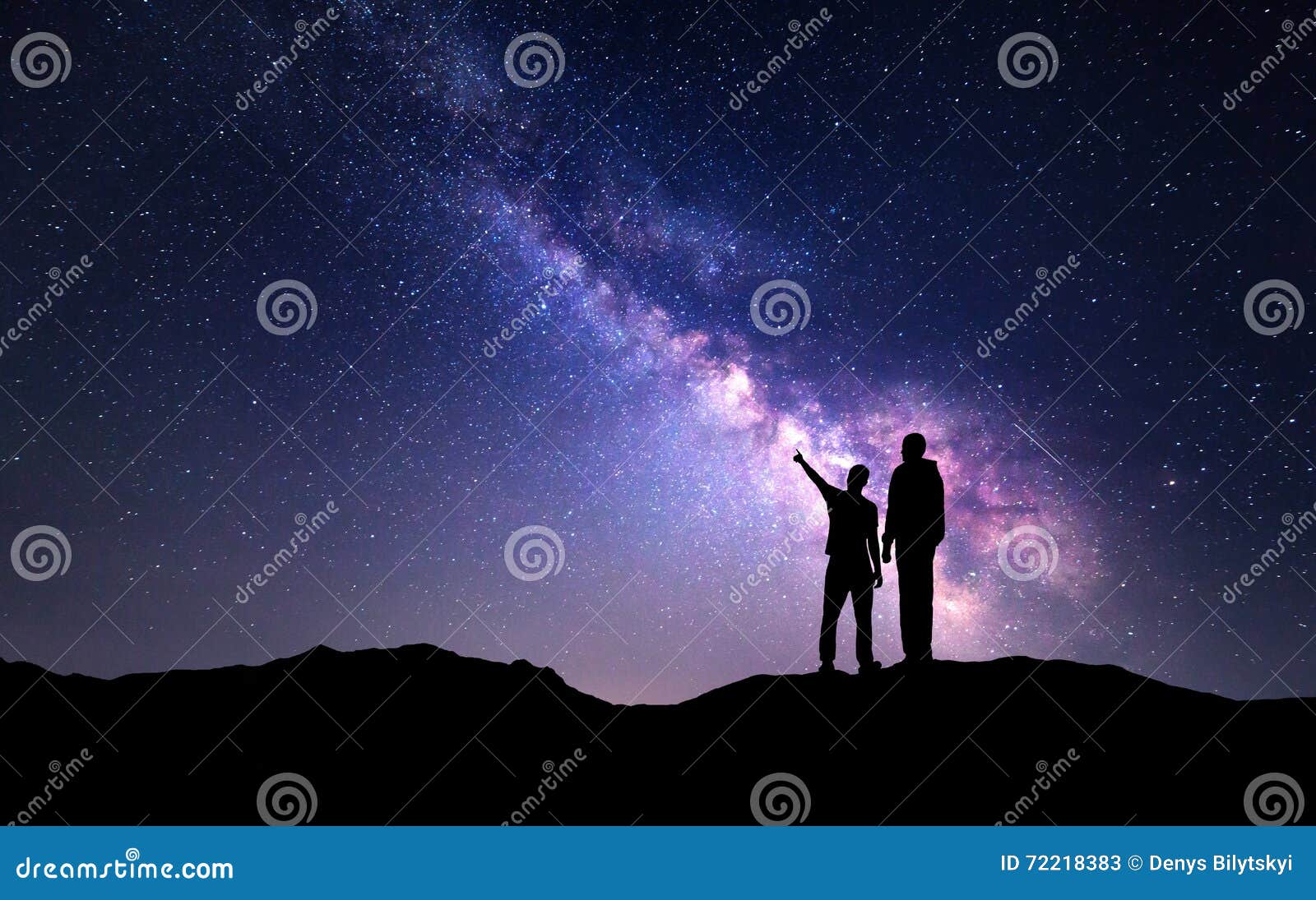 landscape with milky way. silhouette of a father and son