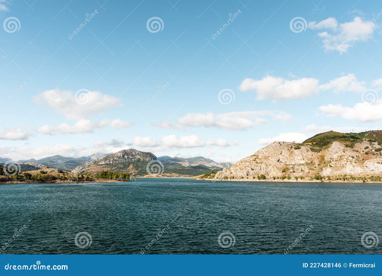 landscape of the mountains and the water of the porma reservoir in castilla y leon in spain.the photo has a blue sky with some