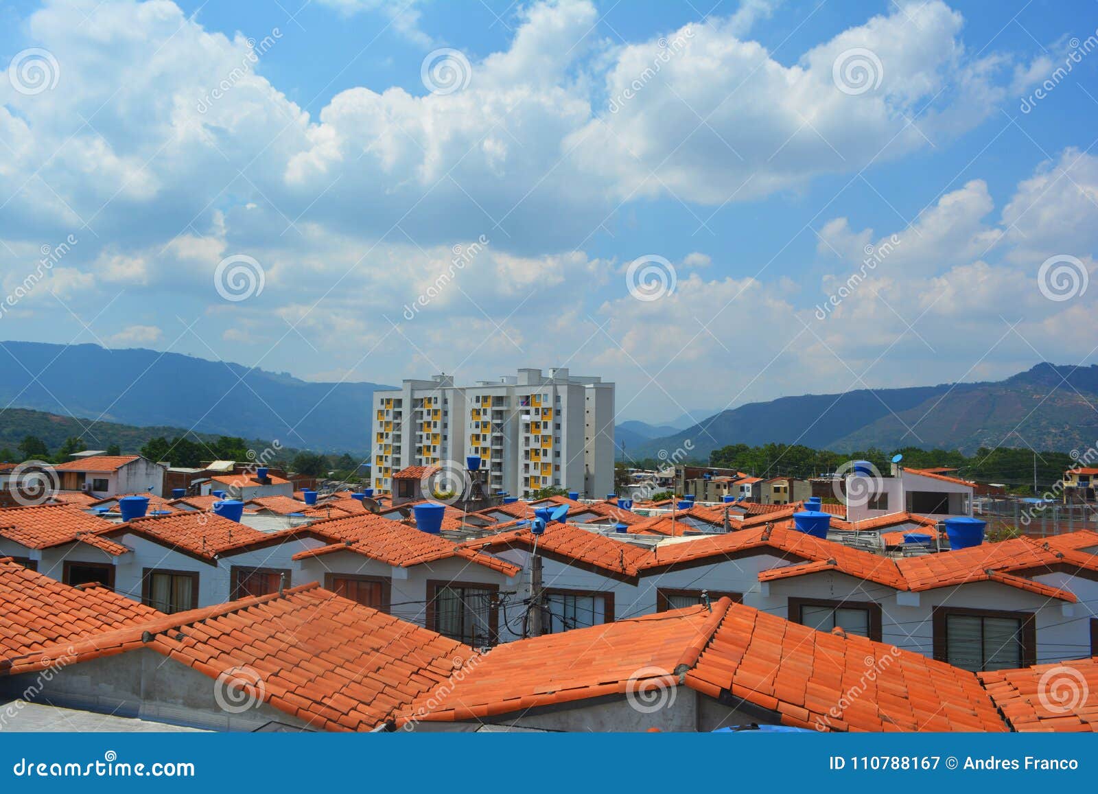 a landscape of some houses seen from the roof with a blue sky in the background