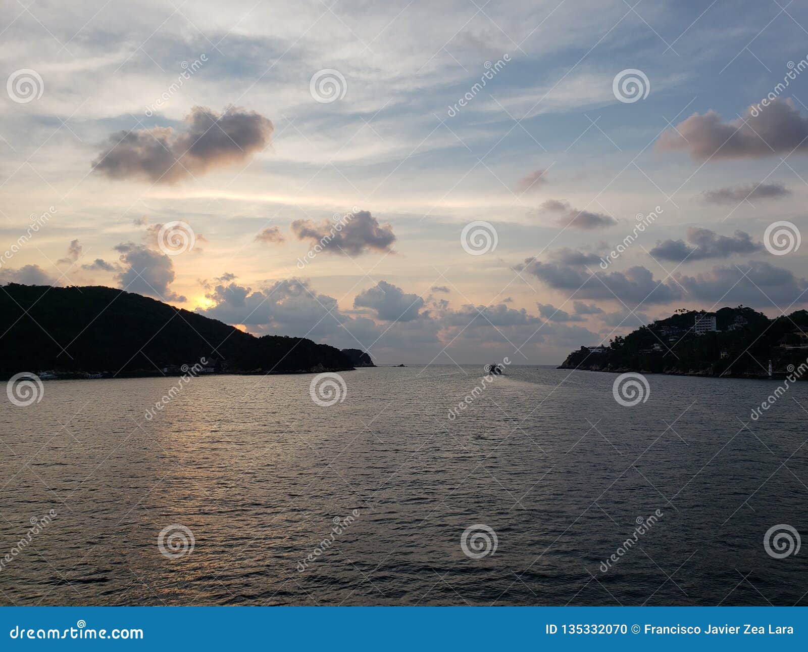 landscape with the tip of the island of la roqueta in acapulco bay at dusk