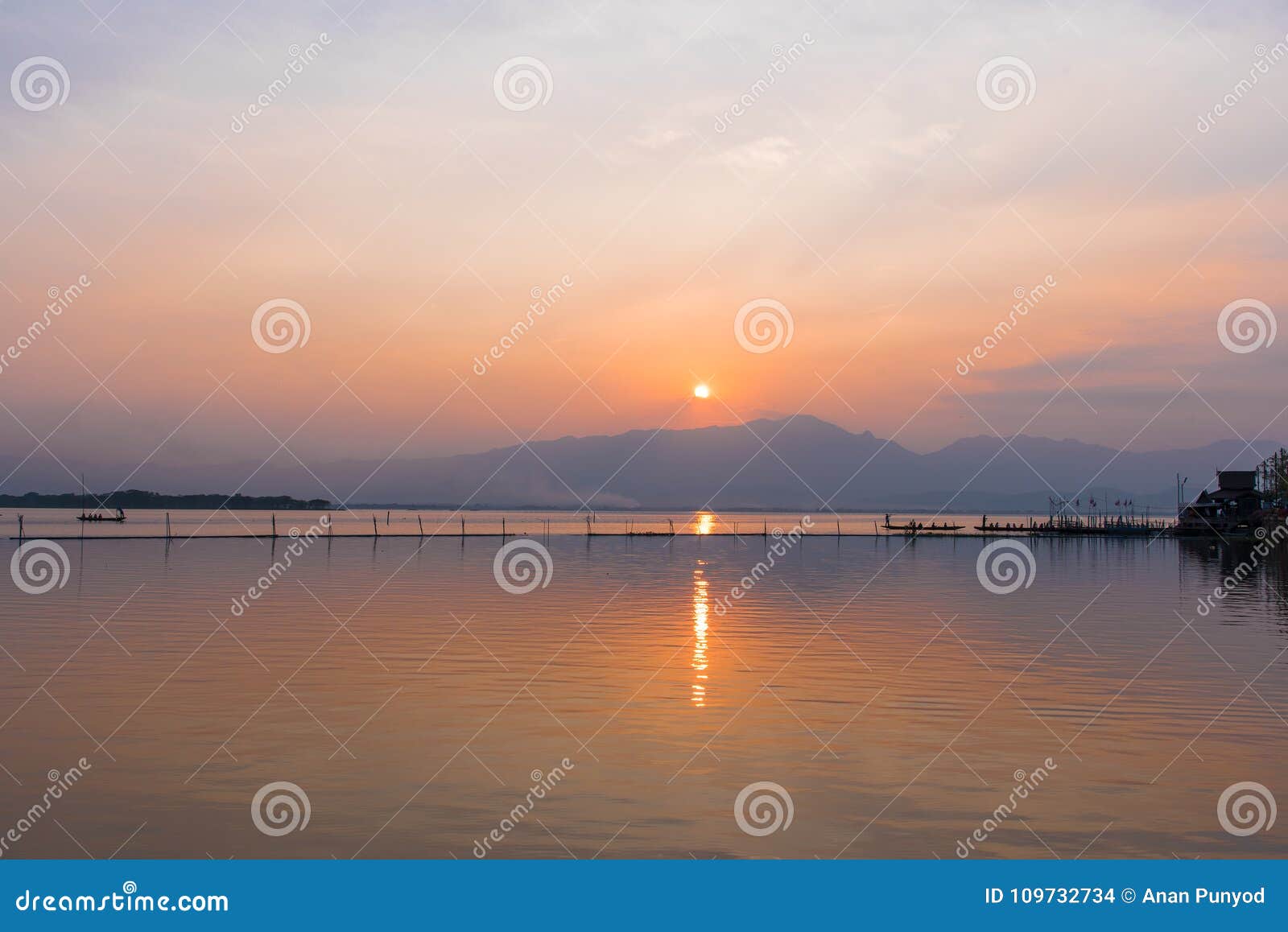 landscape view - boatman paddle boat in the lagoon lake.kwan phayao in evening time at phayao thailand