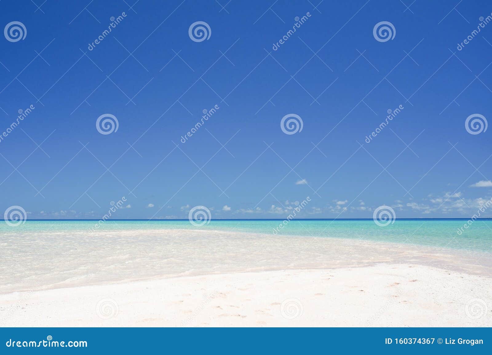 Landscape Of A White Sandy Beach Leading Into Turquoise Waters Under A