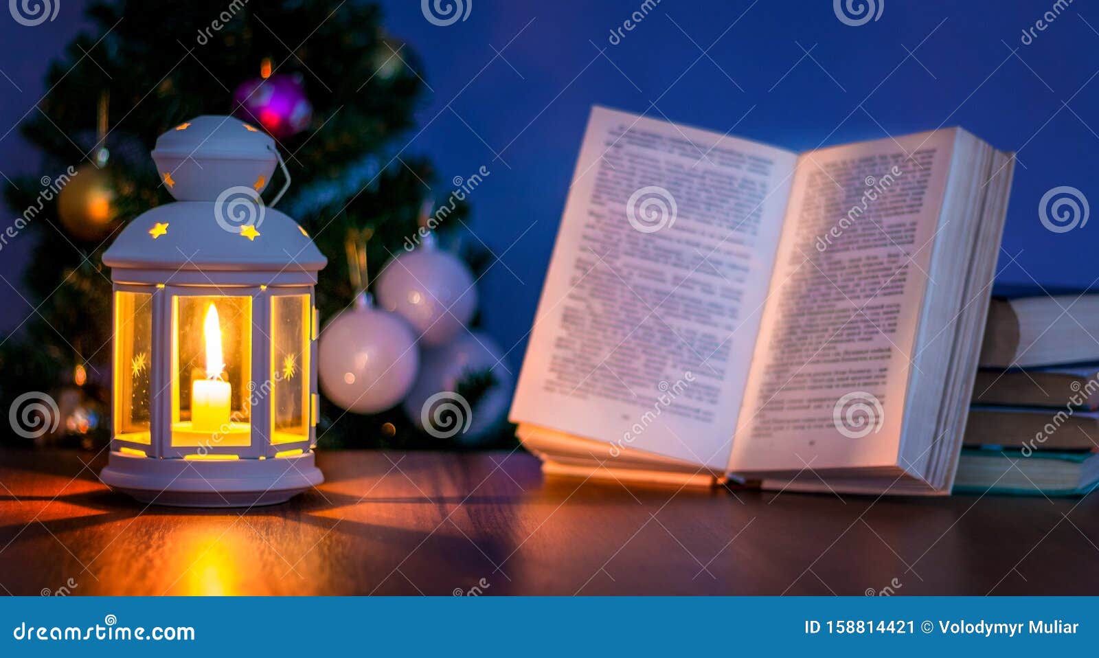 Lantern with Book and Open Book Near Christmas Tree. Reading in Candle