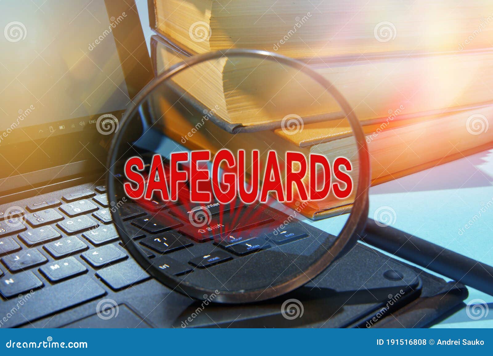 laptop computer and book with text safeguards on magnifying glass
