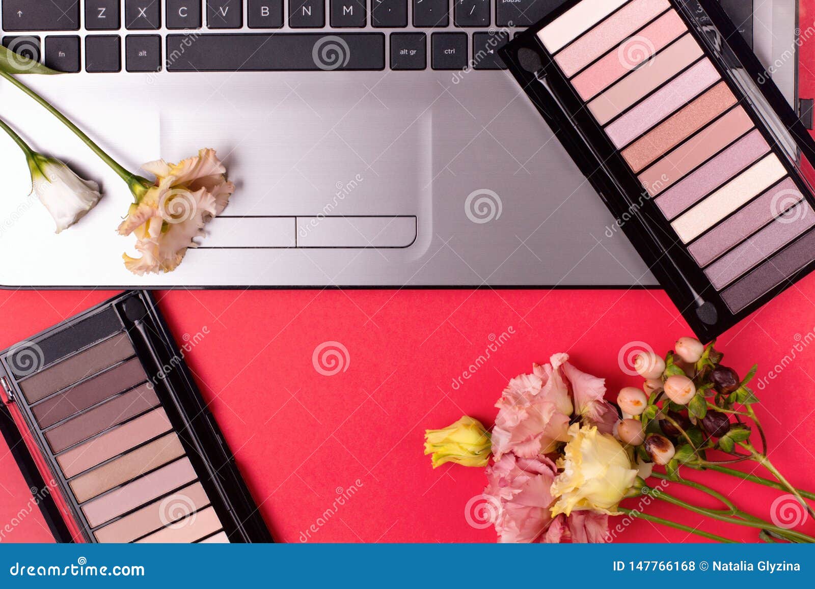 Laptop with Flowers and Cosmetics on Table. Freelancer Workspace Stock