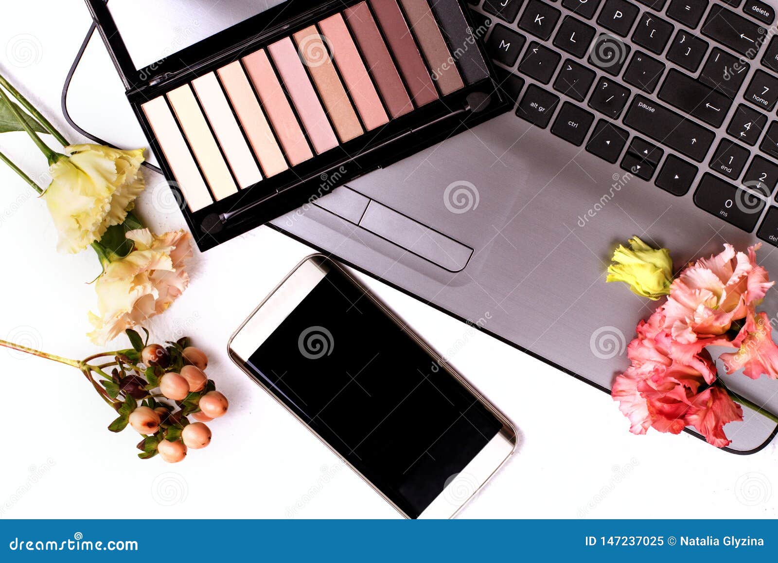 Laptop with Flowers and Cosmetics on White Table. Freelancer Workspace ...