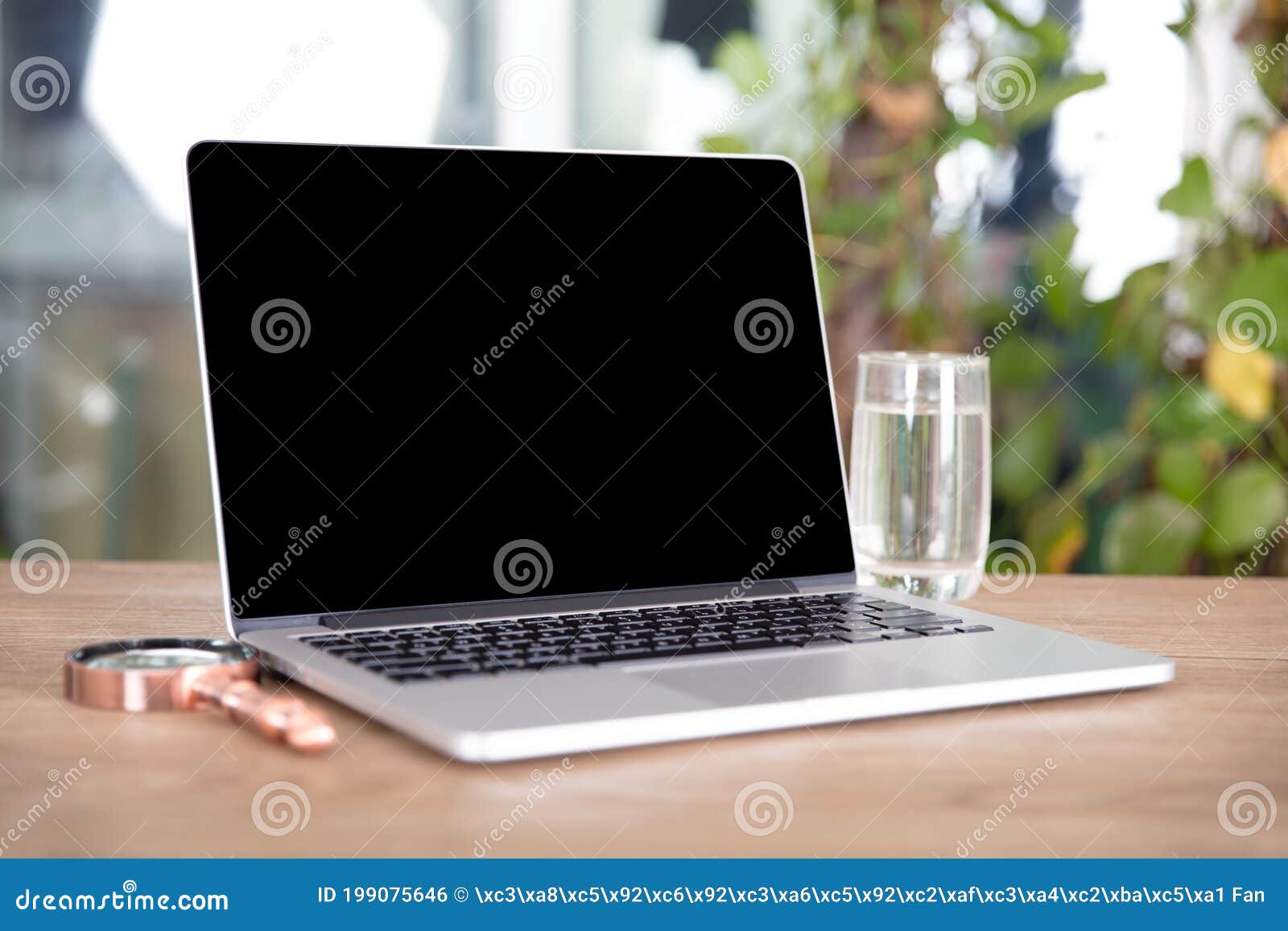 A Laptop with a Glass of Boiling Water and a Magnifying Glass on the