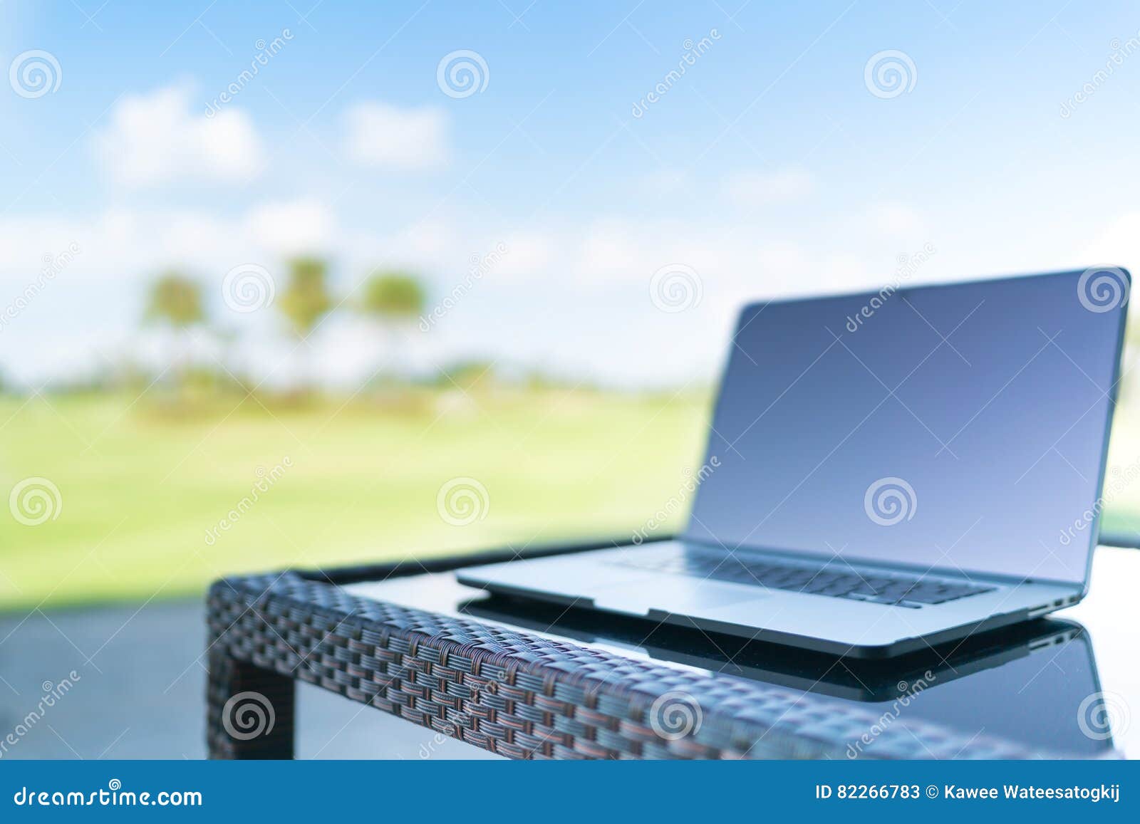 laptop on golf course blur background with copy space, business or work from anywhere concept, depth of field effect