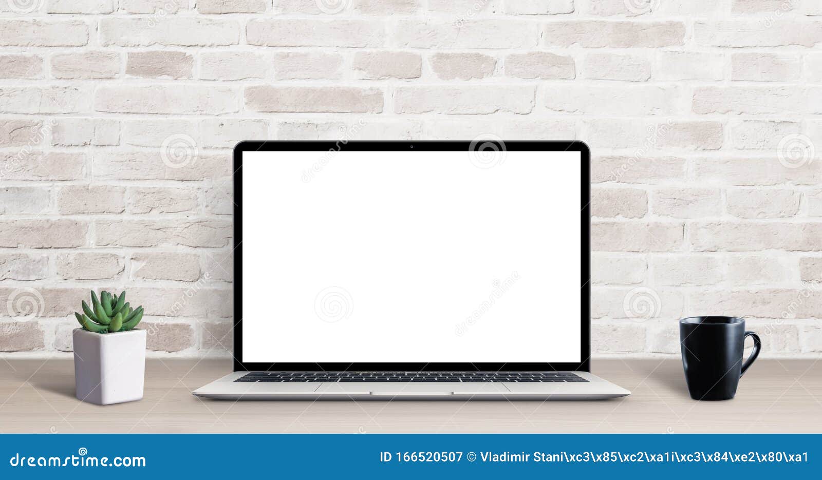 laptop mockup on simple, clean desk with brick wall in background