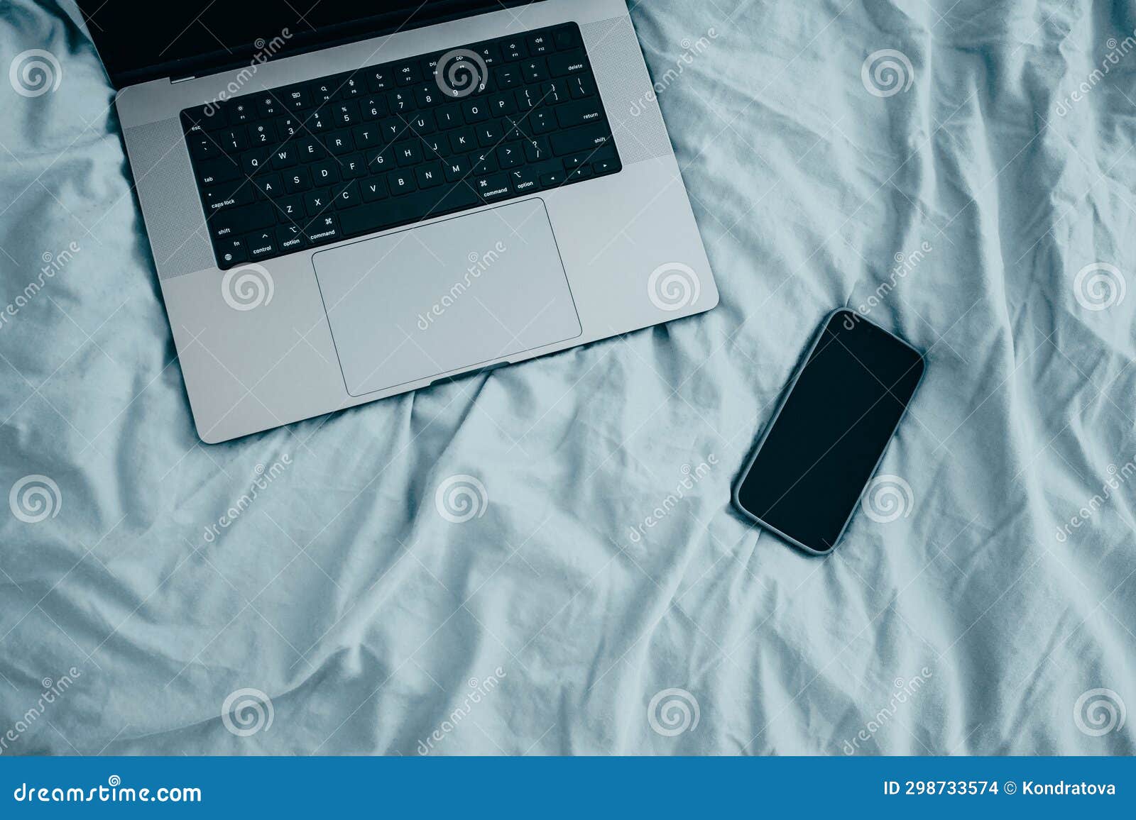 Laptop and Smartphone the Morning on a Blue Sheets Bed. Work from Home