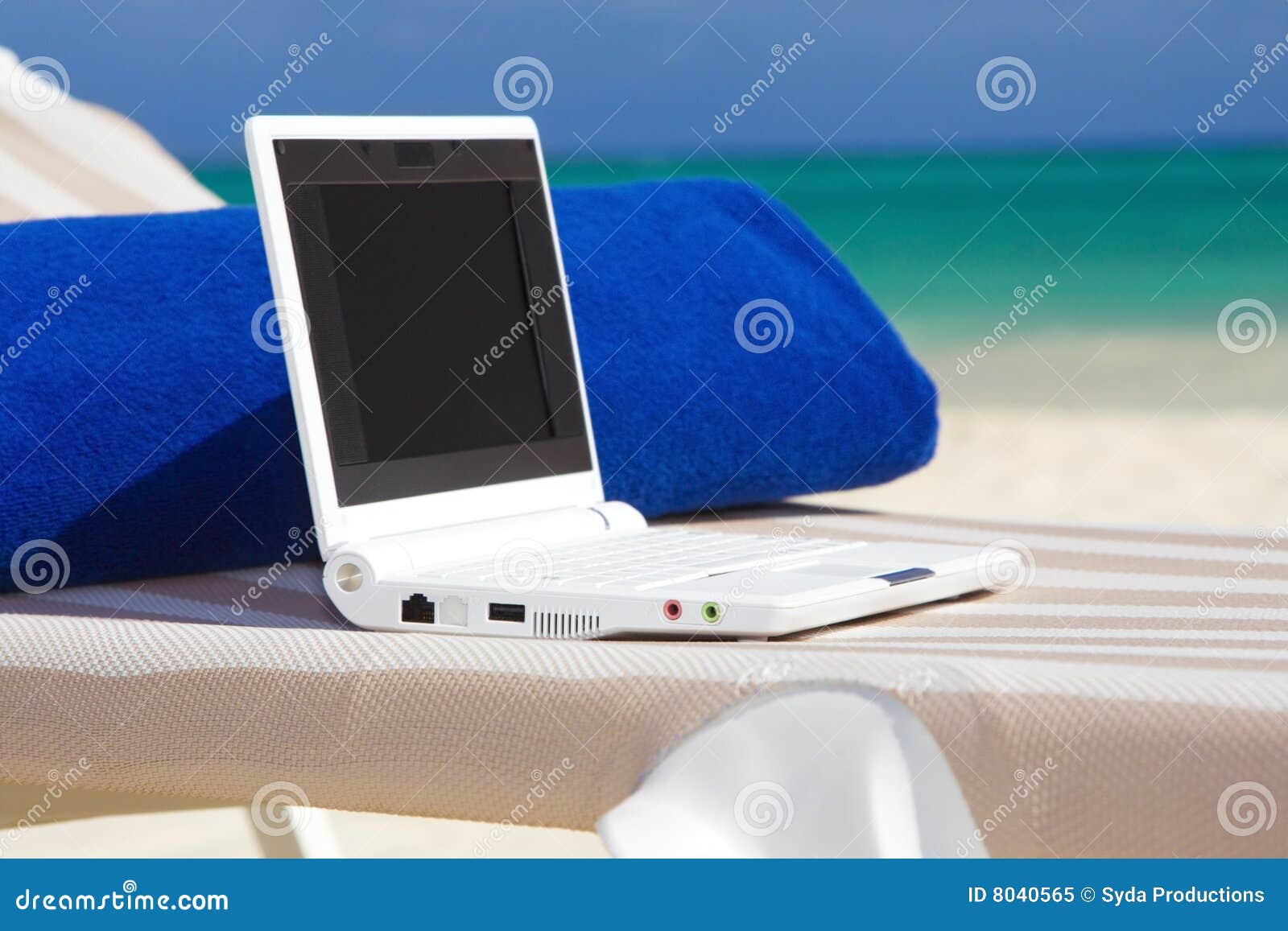 laptop and towel on the beach chaise longue