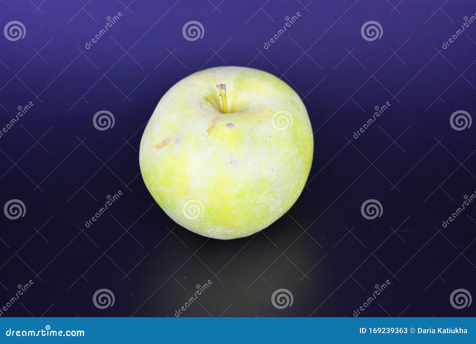 a large bright juicy green yellow apple, varieties renet simirenko is located on a black plastic background.