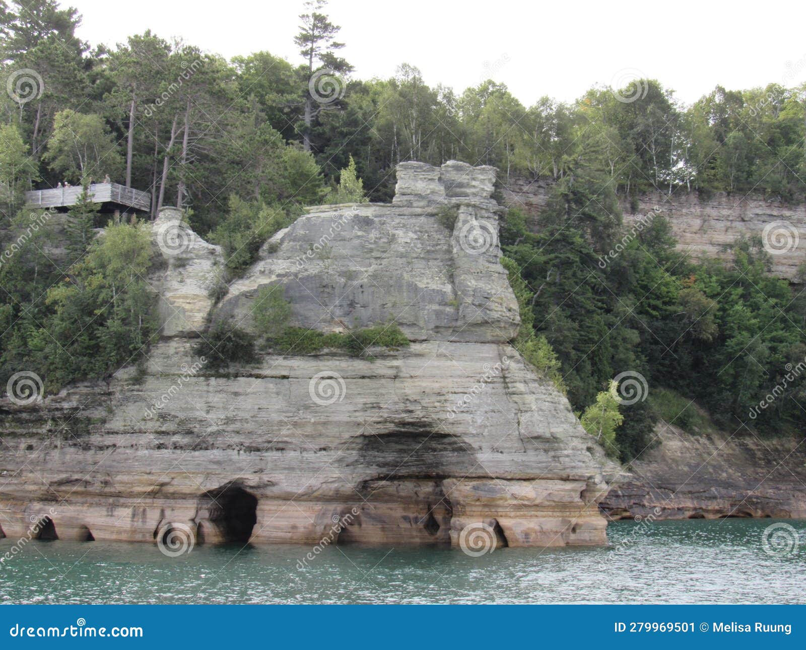 a large cliff with small caves under it