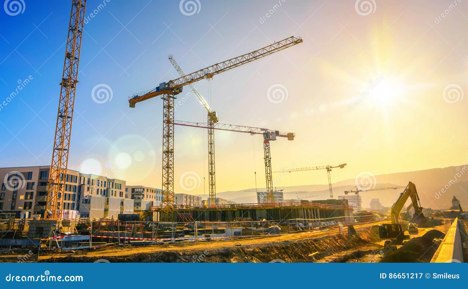 large construction site including several cranes, with clear sky