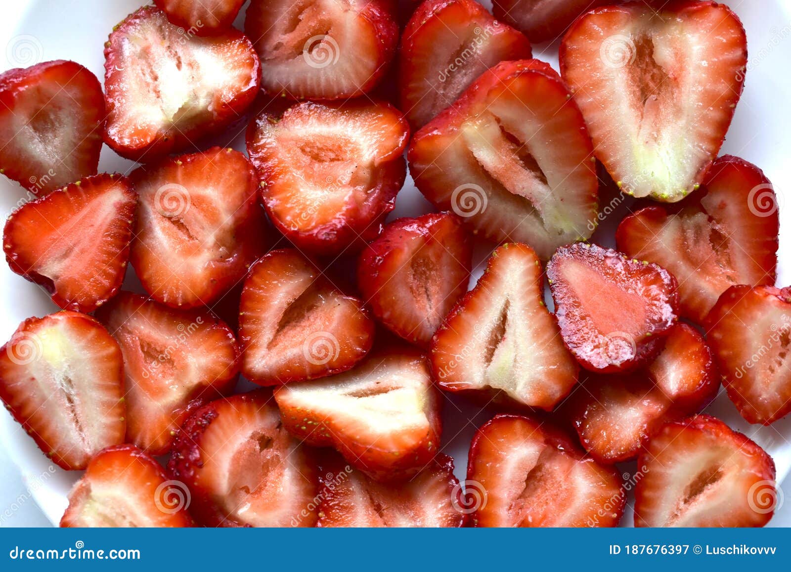 Large Delicious Victoria Berries and Sliced Victoria Berries on a White