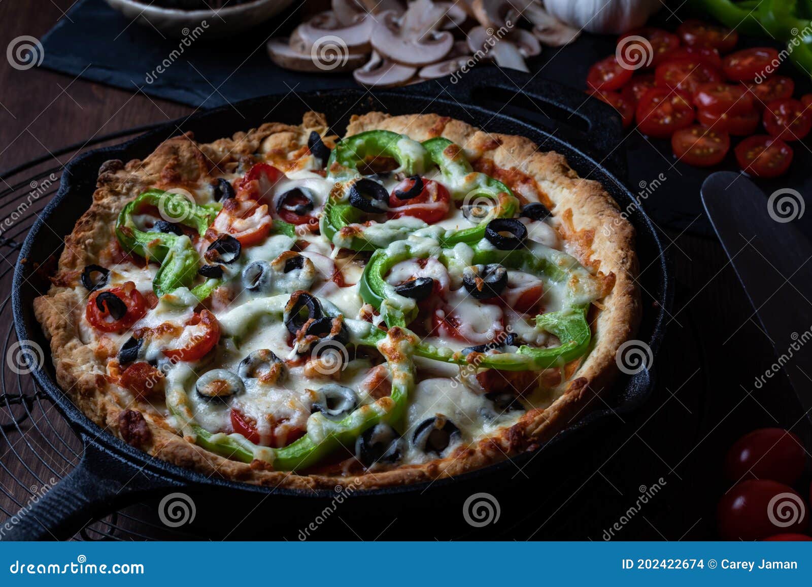 Large Deluxe Deep Dish Pan Pizza Against a Dark Background. Stock Photo