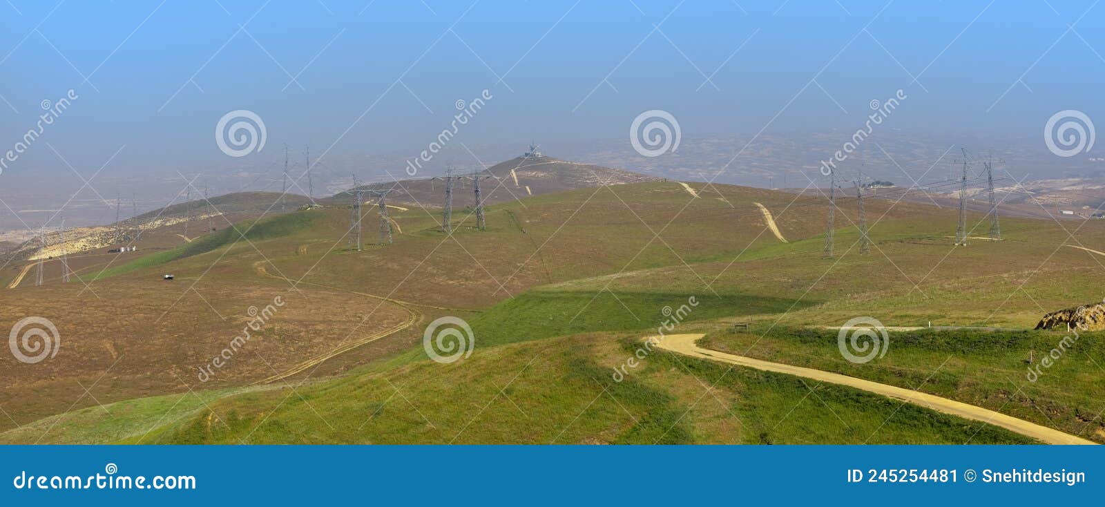 large electrical transmission structures , rolling hills in california covered with mist